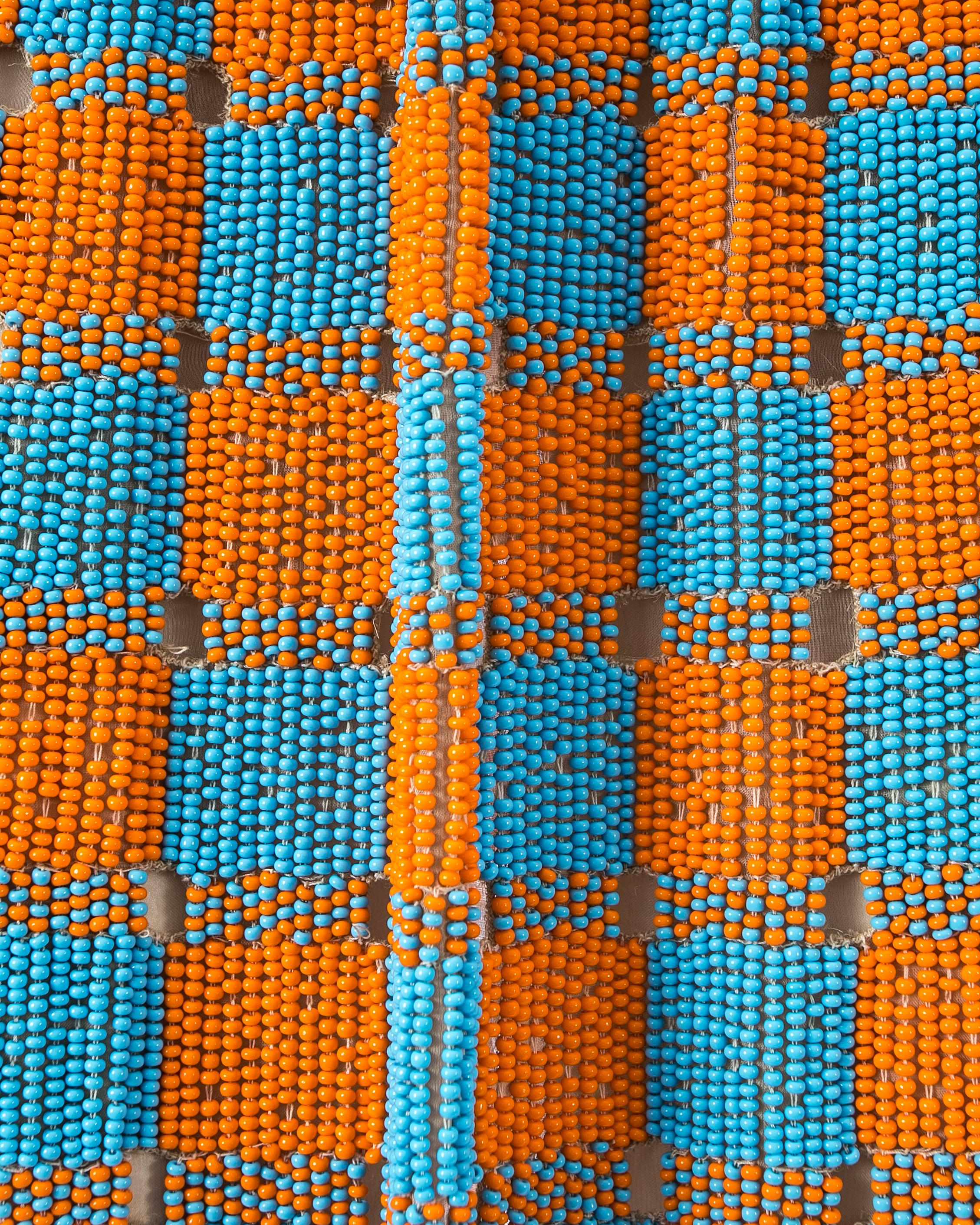 Beaded orange and blue checkered skirt with silk chiffon lining, leather elastic waistband and green beaded fringed trim.

Spring-Summer 1999