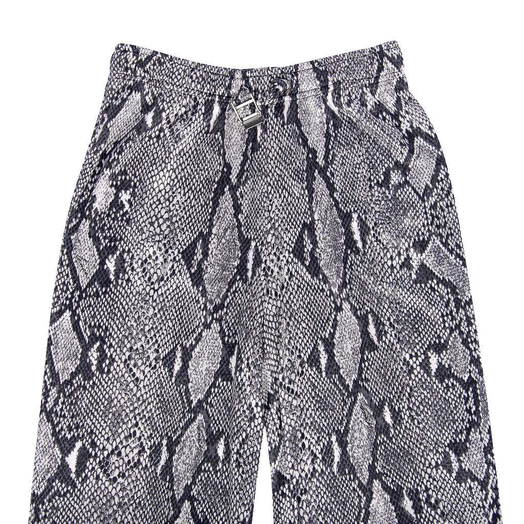 Guaranteed authentic Gucci by Tom Ford circa 2000 black, grey and silver snake print slinky pant.
Elasticized waist has self tie with silver Gucci embossed buckle.  
Subtle signature logo in front and back. 
Silver logo detail on working zipper at