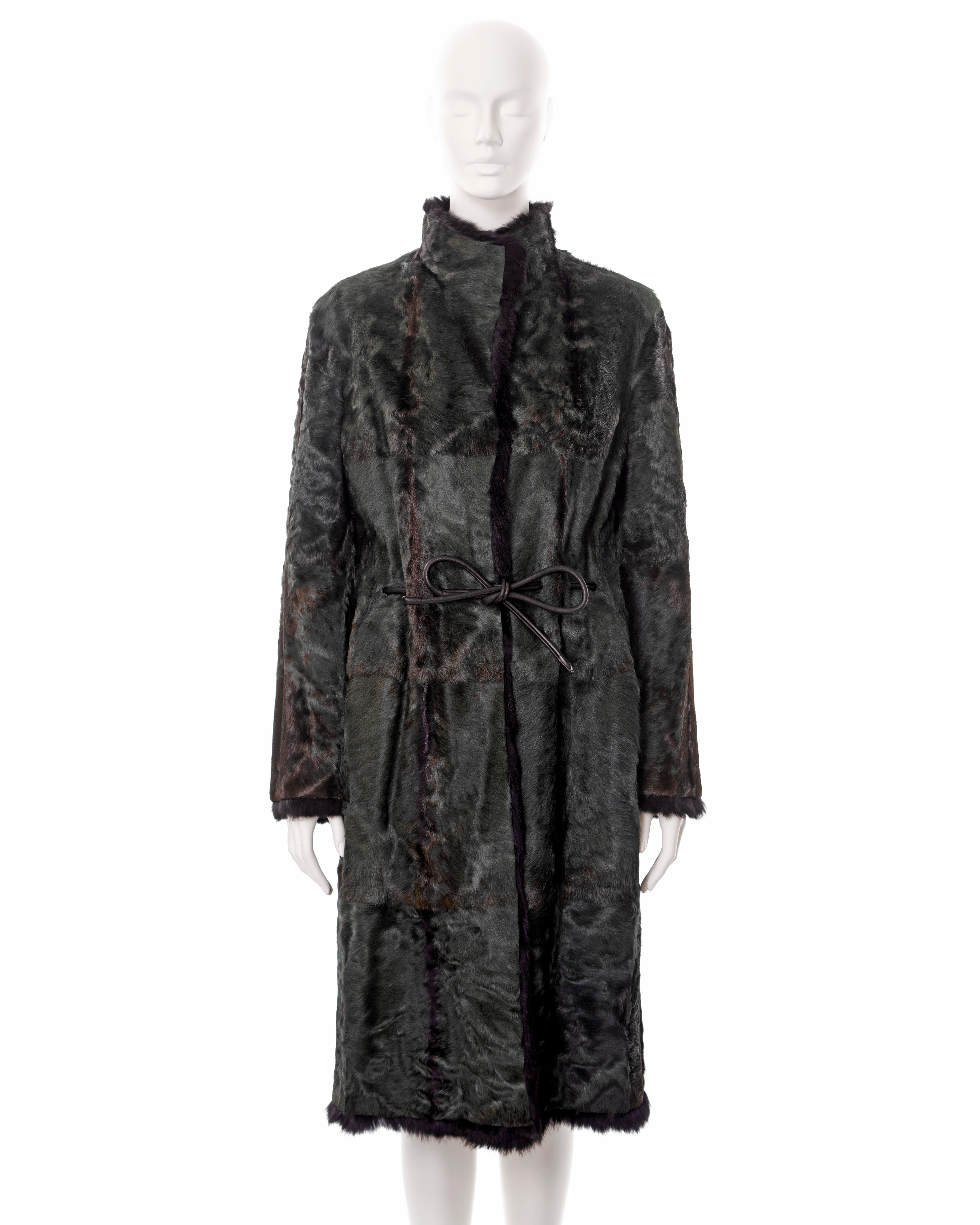 ▪ Gucci fur coat 
▪ Designed by Tom Ford
▪ Sold by One of a Kind Archive
▪ Fall-Winter 1999
▪ Constructed from bottle-green dyed Persian lamb and black rabbit fur 
▪ Black leather ribbon drawstring belt 
▪ Standing collar 
▪ Front hook closures 
▪