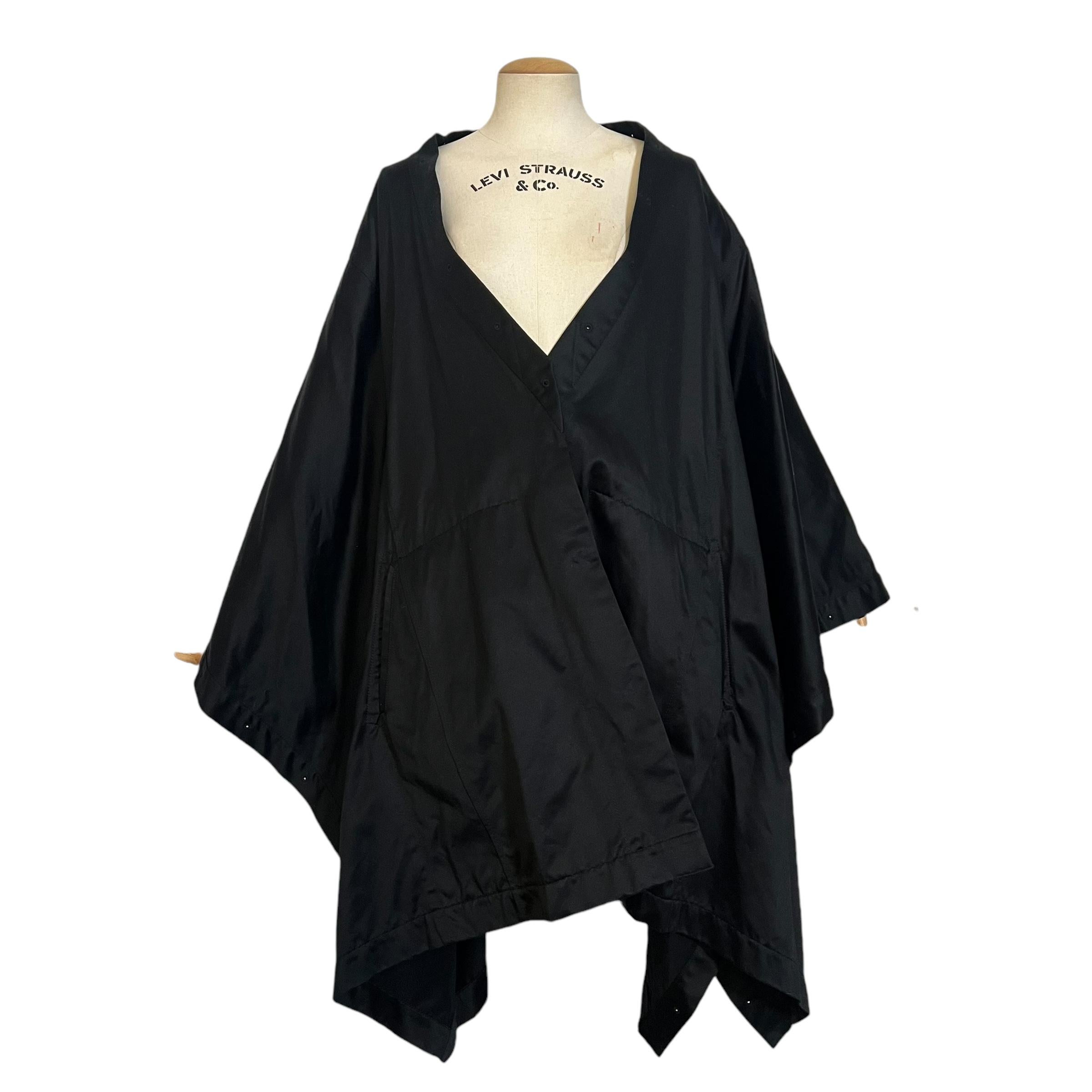 A striking black oversized kimono jacket from Gucci's iconic Fall/Winter 2002 collection, designed by Tom Ford. Crafted in 100% cotton with a luxurious satin-like finish, this piece features two functional snap buttons for versatile styling and two