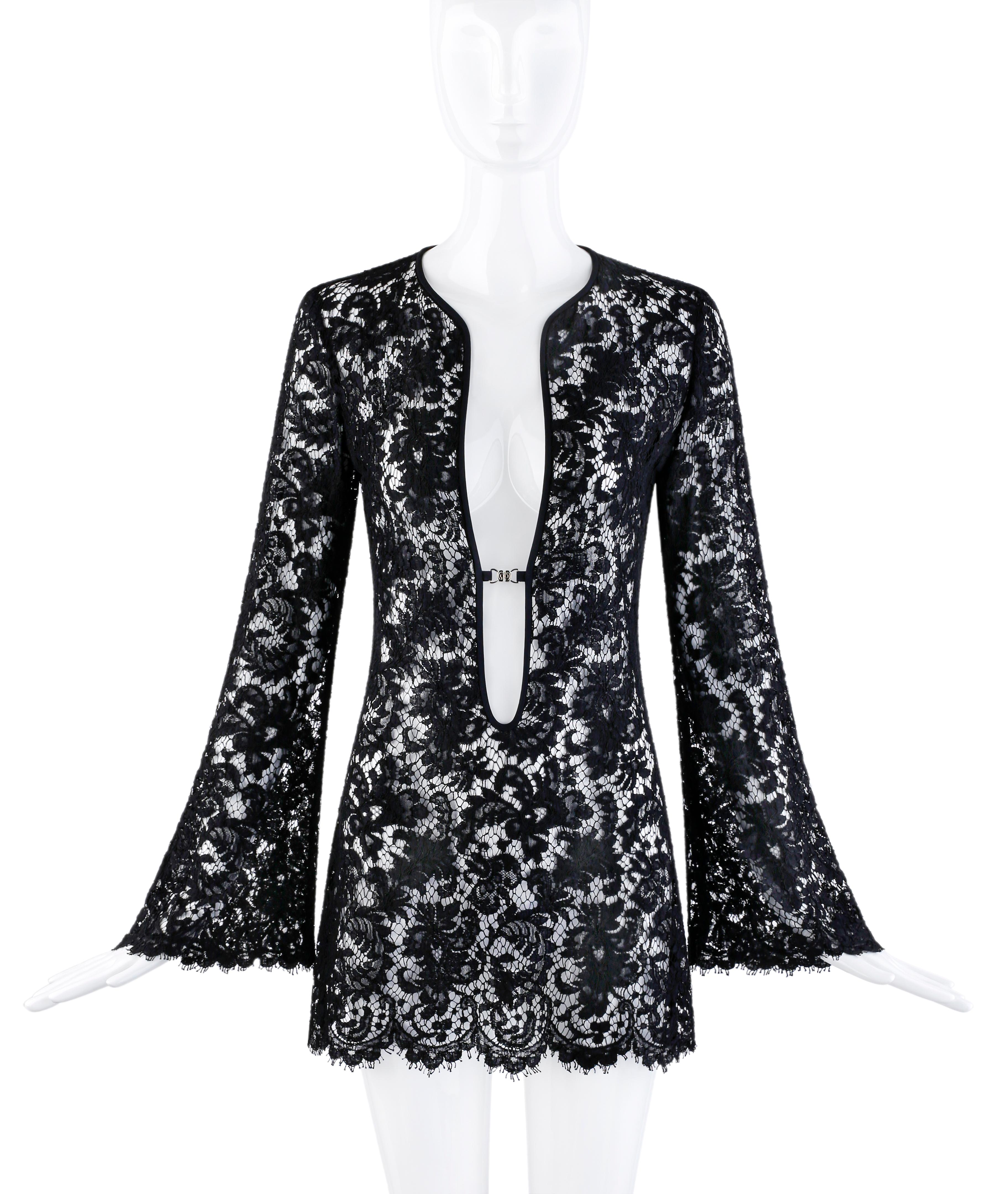 From Gucci’s Spring/Summer 1996 collection, designed by Tom Ford. Black semi-sheer lace knit construction, long bell sleeves, scalloped hemline, plunging neckline with black trim and a single metal “GG” interlocking closure. Can be worn as a mini