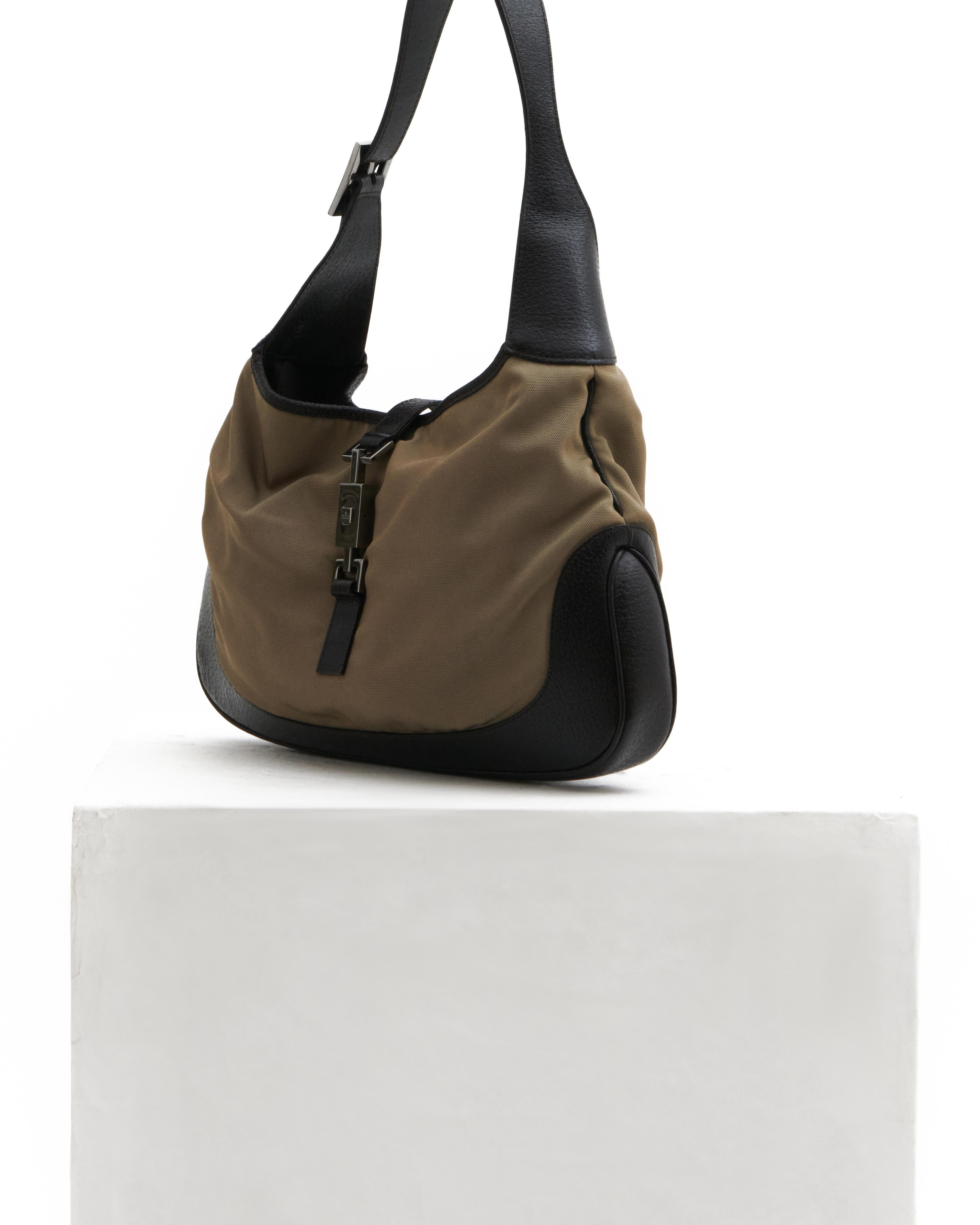 - Designed by Tom Ford 
- Sold by Skof.Archive 
- Classic hobo is crafted of khaki nylon and black leather
- Black leather at the base and sides 
- Closure/Opening: piston strap closure 
- Handle: a looping shoulder strap with a cross-over strap 
-