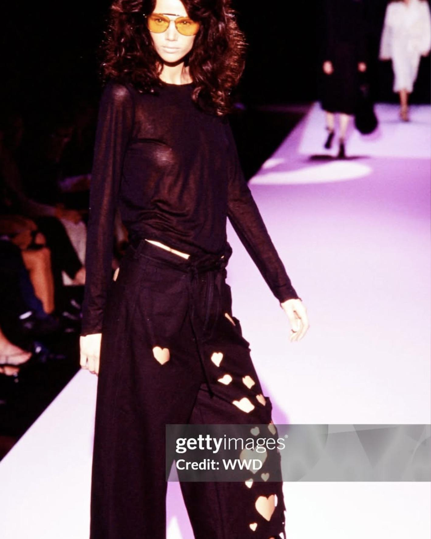 - Conçu par Tom Ford
- Vendu par Skof.Archive
- Collection printemps-été 2002
- Débardeur blanc boutonné et jupe en denim Hearts
- Rangée verticale de petites fermetures métalliques à crochets sur le milieu du devant
- Dos nu avec larges bretelles
-