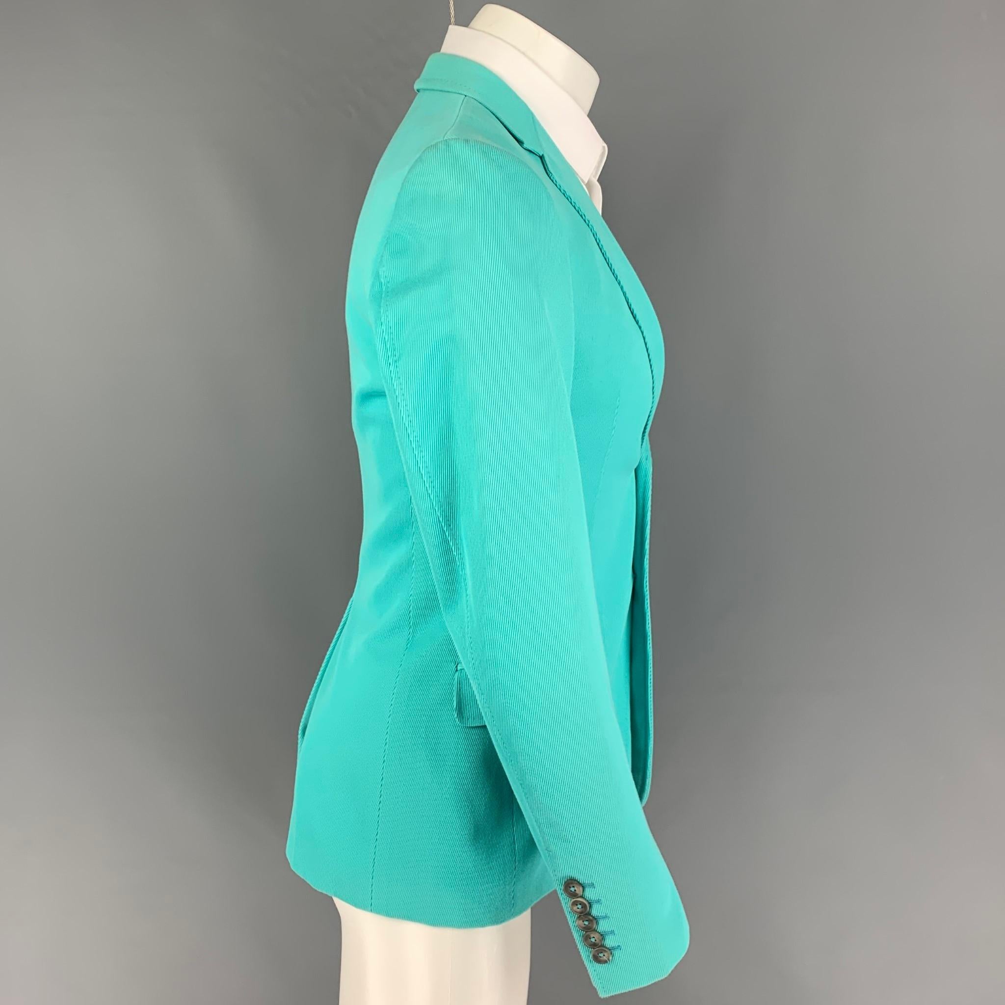 GUCCI by Tom Ford sport coat comes in a aqua textured cotton with a full liner featuring a notch lapel, flap pockets, single back vent, and a double button closure. Made in Italy. 

Very Good Pre-Owned Condition. Light discoloration at