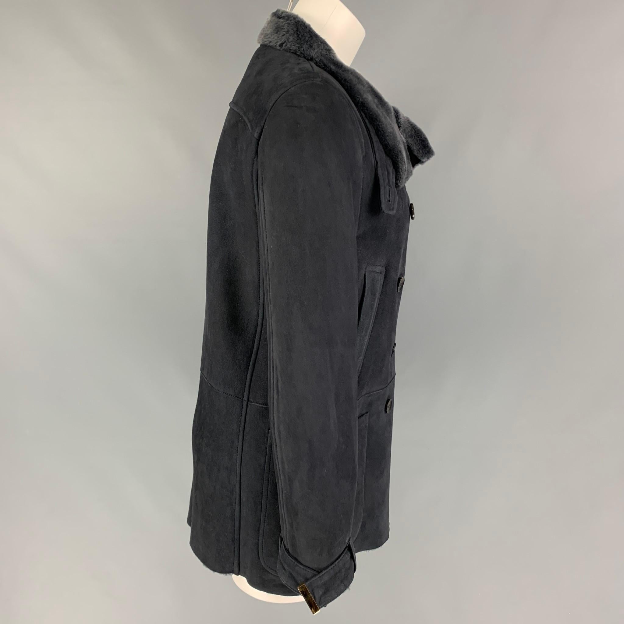 GUCCI by Tom Ford coat comes in a grey shearling with a fur interior featuring front pockets, gold tone hardware, strap cuffs, and a double breasted closure. Made in Italy. 

Excellent Pre-Owned Condition.
Marked: 42

Measurements:

Shoulder: 15.5