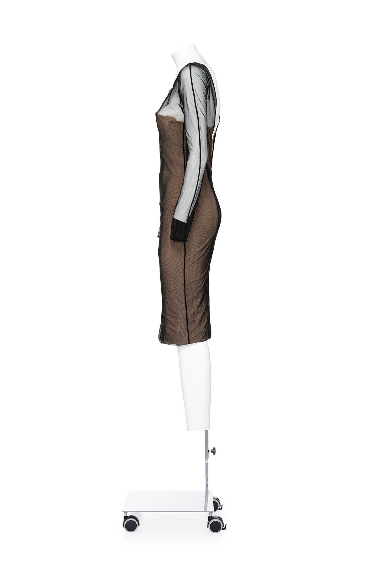 Primavera Verano 2001 Icónico vestido de malla transparente de manga larga de Gucci by Tom Ford.
Vestido corpiño de ballenas sin tirantes debajo.
La composición es 86% nailon 14% elastano