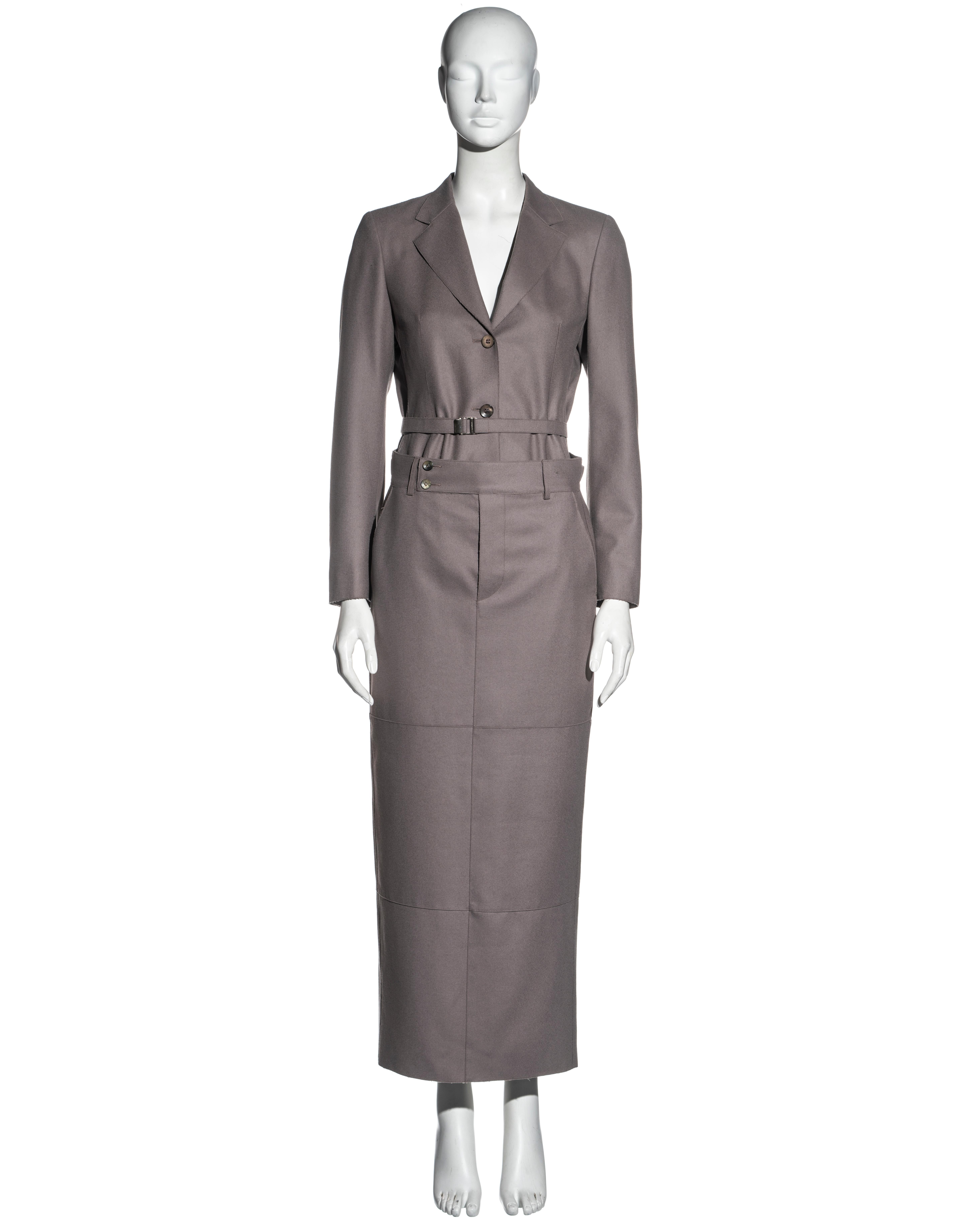 ▪ Traje con falda de fieltro de lana de color topo de Gucci 
▪ Diseñado por Tom Ford
▪ Chaqueta de un solo pecho con cinturón a juego
▪ Falda tobillera con dos bolsillos traseros con solapa
▪ Botones de nácar 
▪ Costuras de puntada superior 
▪