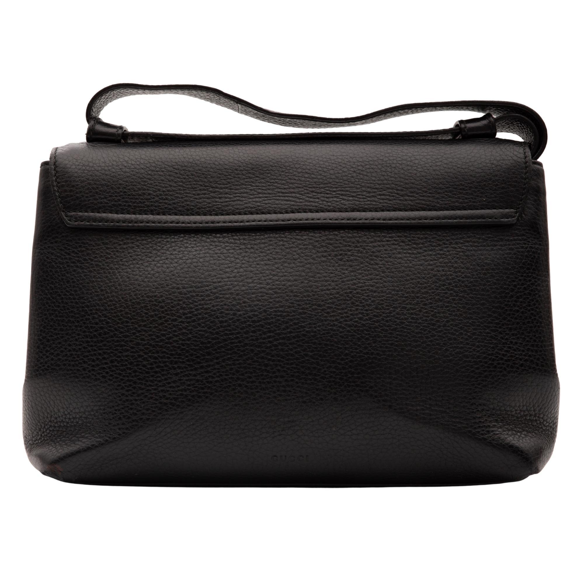 Questa borsa a tracolla è realizzata in pelle di vitello testurizzata di colore nero. Questa borsa presenta una tracolla regolabile in pelle, una patta incrociata, finiture in ottone, un logo GG intrecciato sul davanti e un interno in tessuto beige