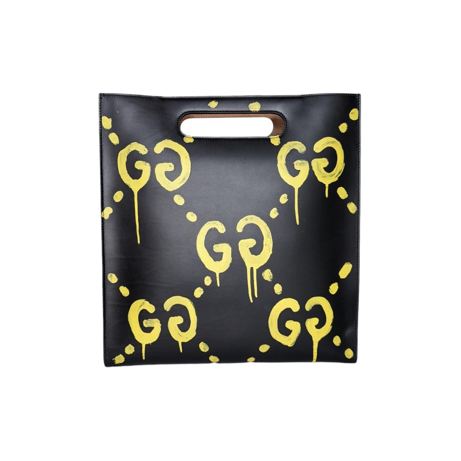 This unisex tote is crafted of black smooth calfskin with yellow painted GGs. The bag features customized art by artist Trouble Andrew, a large Gucci embossed lettering and a long leather adjustable shoulder strap. The top opens to a spacious beige