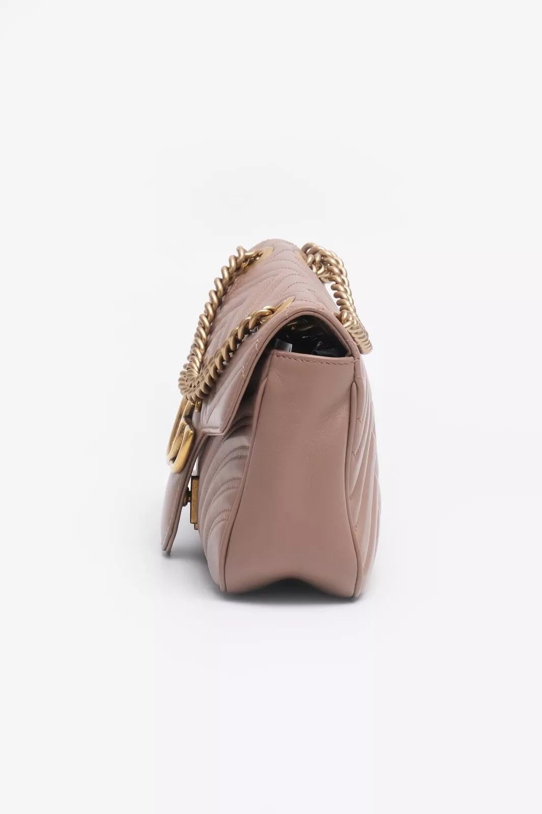 GUCCI Small GG Marmont Shoulder Bag in Porcelain Rose features a supple nude-pink calfskin, an aged gold chain strap with a leather pad, and a GG logo flap. The microfiber interior includes a zipper pocket.


Material: Calfskin Leather 
Color: Light
