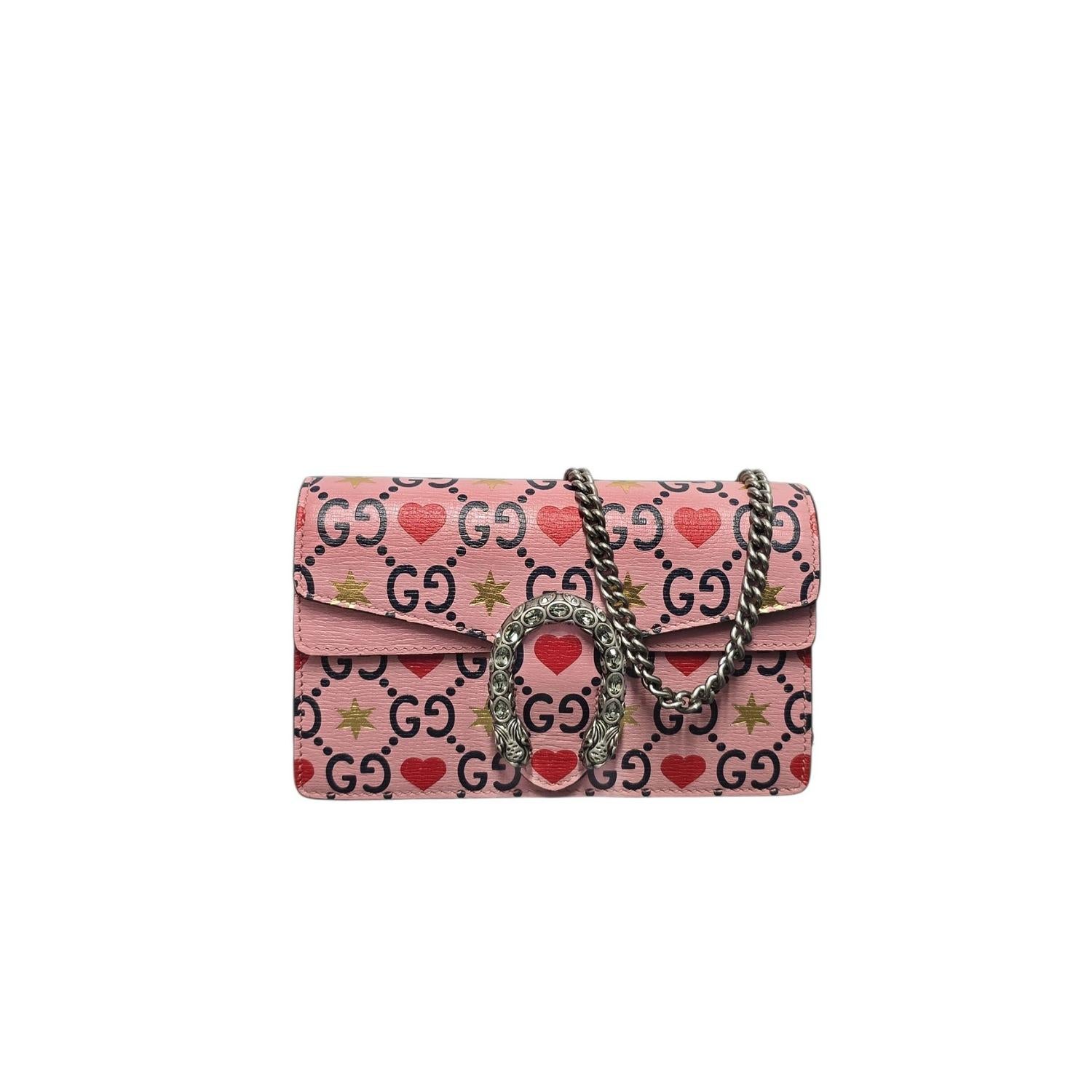Un trésor de Gucci en édition limitée pour la Saint-Valentin. Ce mini sac Dionysus est en cuir de veau rose italien et porte un monogramme romantique. Les cœurs rouges et les étoiles dorées accrochent magnifiquement la lumière. Le fermoir iconique