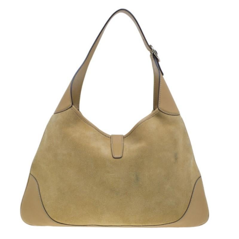 Complete a casual look with this camel Gucci suede studded Hobo. It features a suede exterior with silver-tone stud detailing down the middle. It also features leather trim and a leather handle. The silver-tone lobster clasp opens up to a spacious