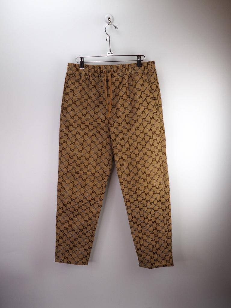 Gucci Canvas Jacquard Jogging Pants, this jogging pant is crafted from GG cotton canvas, in a classic combination of beige and ebony, a material often used in tailoring pieces and traditional silhouettes. Featuring horn buttons, elastic waistband