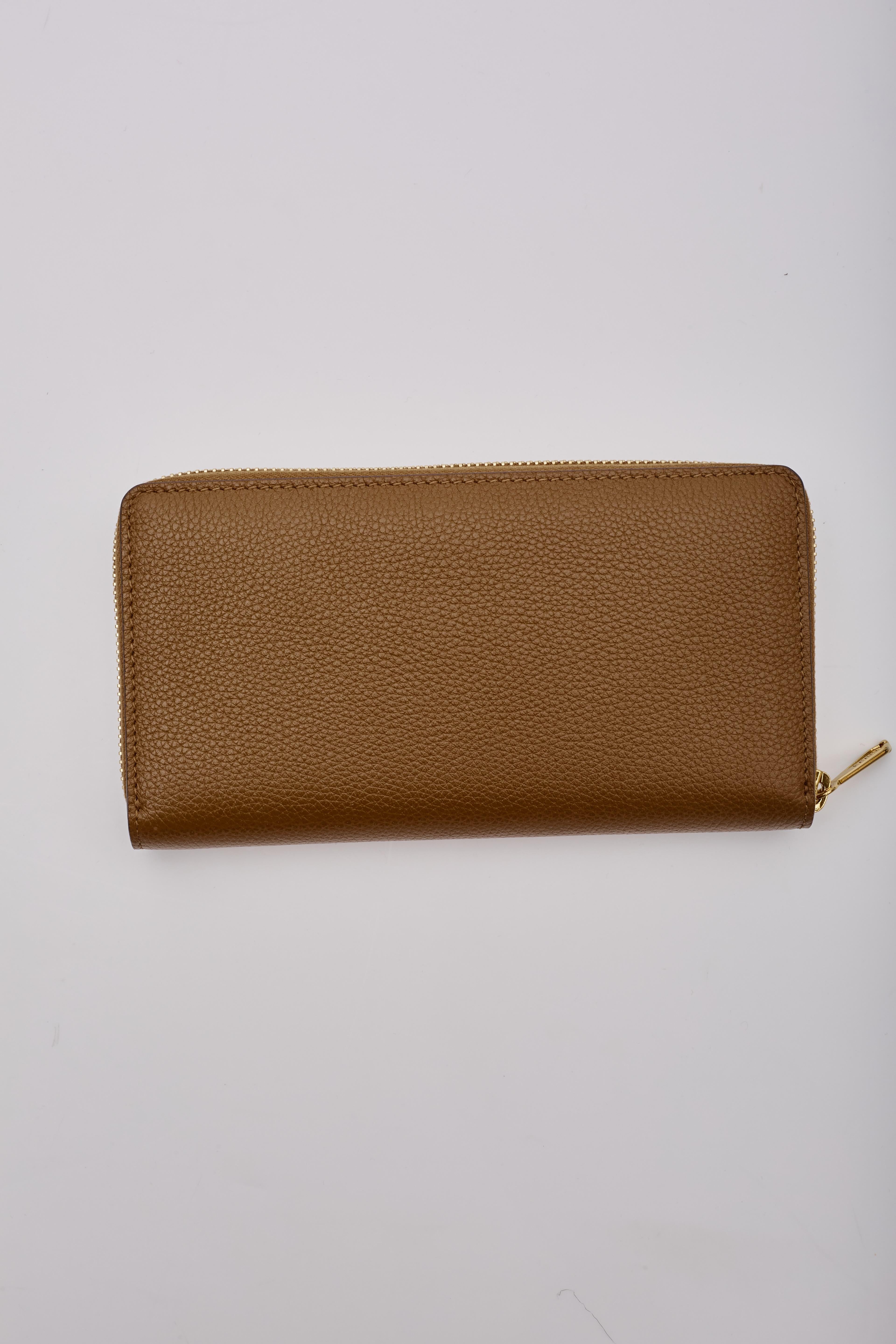 Gucci Zumi Brieftasche aus Leder mit Reißverschluss. Sie ist aus Leder gefertigt, hat eine Posillipo-Narbung, helles Feingold und dunkle Silberbeschläge, ein ineinandergreifendes G-Logo mit Hufeisen-Detail und ein Innenfutter aus Leder und Stoff mit
