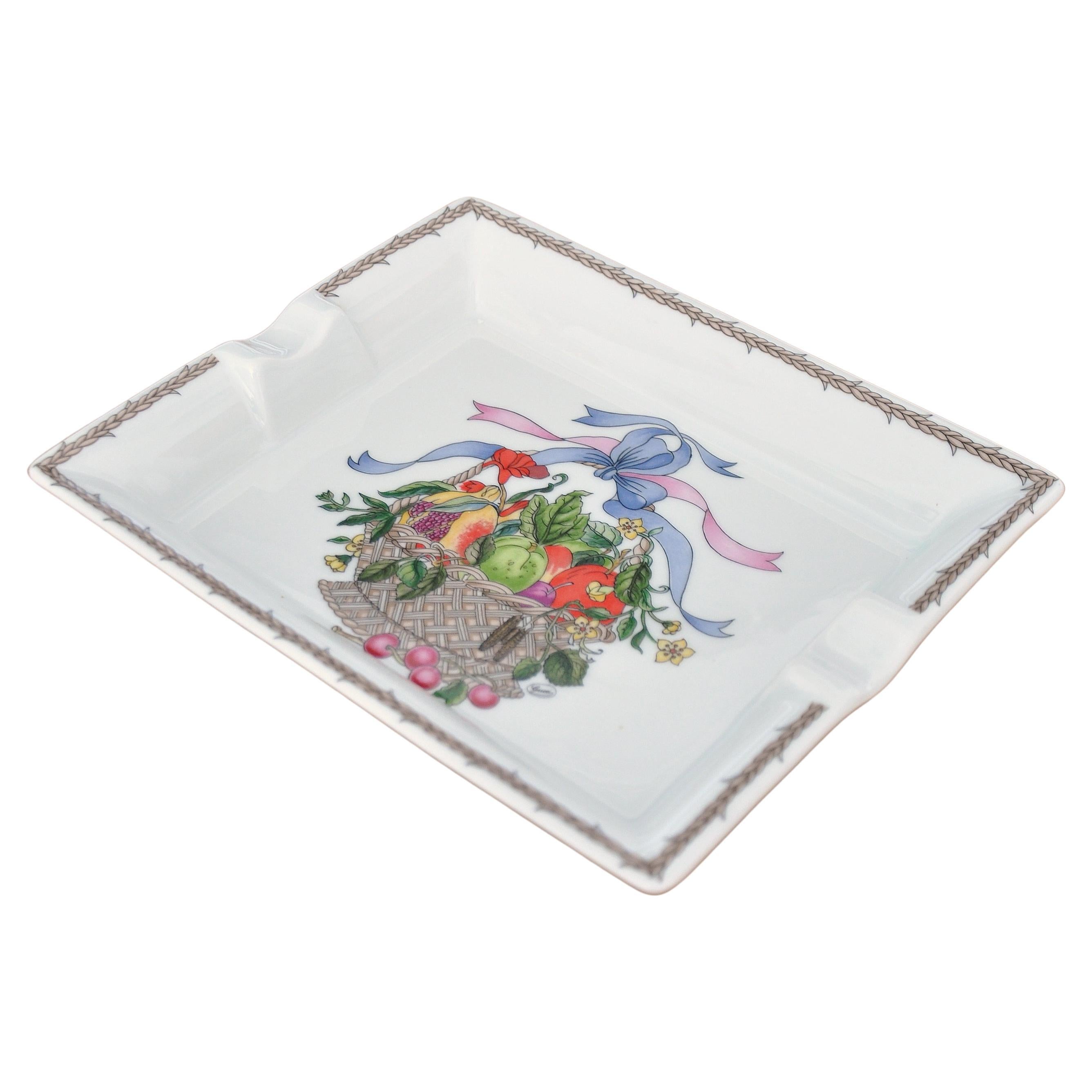Fine porcelain Gucci cigar ashtray from the 'Cestri e Nastri' (Baskets & Ribbons) collection. Made in France by Limoges. Decorated with a basket of fruit and flowers, a blue ribbon, a pink ribbon and a braided border; all with intricate details. The