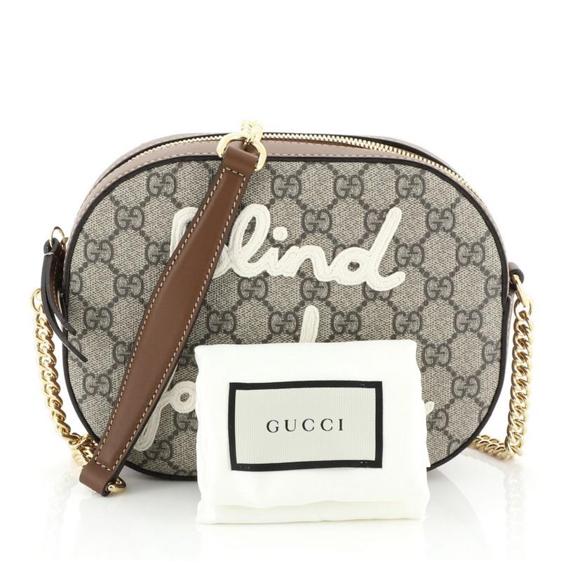 This Gucci Chain Crossbody Bag Embroidered GG Coated Canvas Mini, crafted from brown GG coated canvas, features chain link strap with leather pad, embroidered detail, and gold-tone hardware. Its zip closure opens to a neutral microfiber interior.