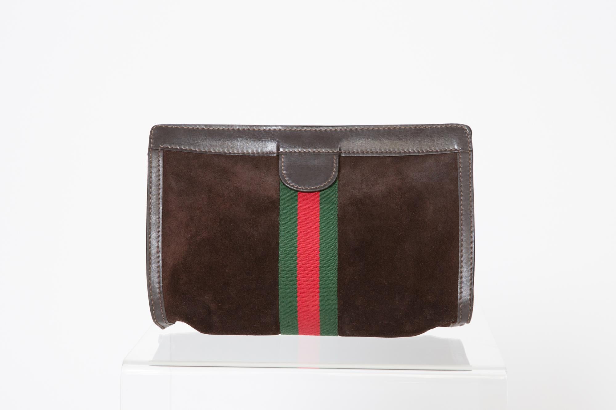 Gucci chocolate leather & suede clutch bag featuring an iconic 'GG' red and green ribbon part, inside logo lining, a velcro scratch band opening and an internal logo stamp.  
 Heigh 7in. (18cm)
Length 10.6in (27cm)
Width 2.7in (7cm)
In good vintage