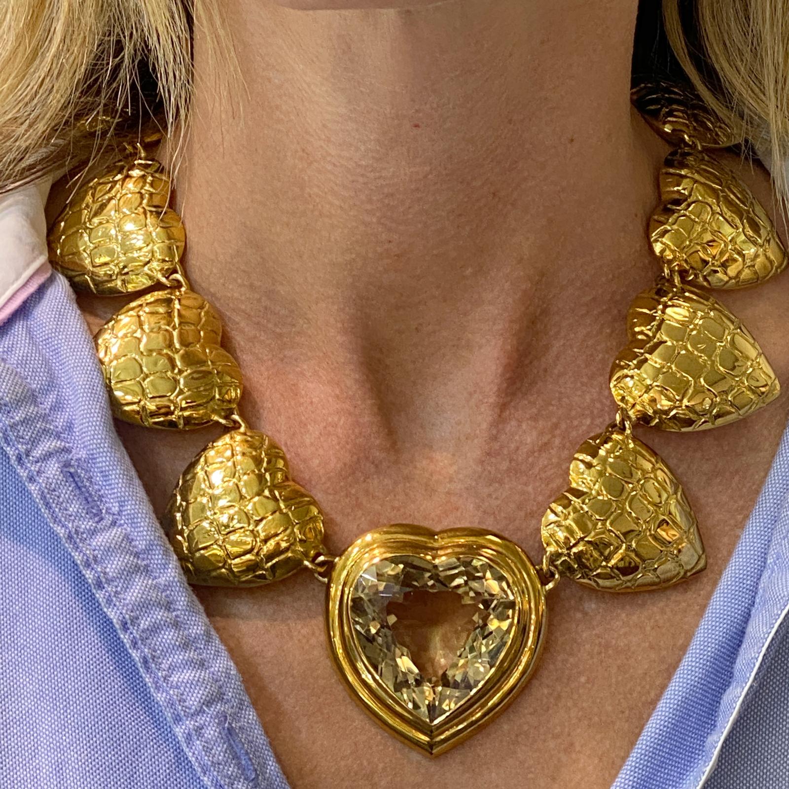 Fabulous vintage gold necklace by Gucci. The heart necklace is fashioned in textured  18 karat yellow gold and features an approximately 60 carat heart shape citrine gemstone. The citrine center measures 2 x 2 inches, and the gold hearts measure 1.5
