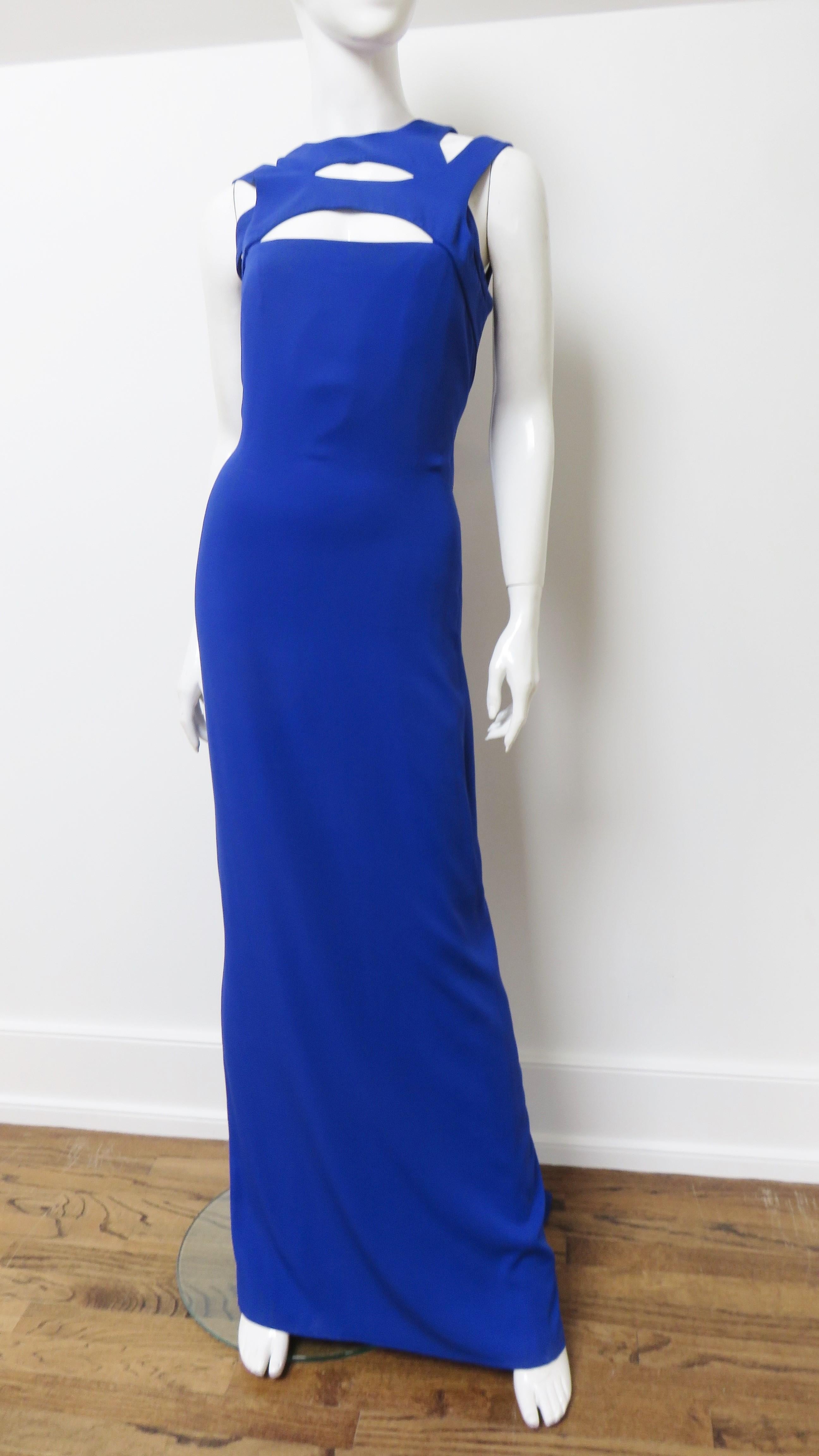 A gorgeous cobalt blue silk gown from Gucci.  It has multiple straps in front creating oblong cut outs and a cut out at the upper back also.  It skims the body and has a straight skirt with a small  train in the back.  It is lined in matching silk,