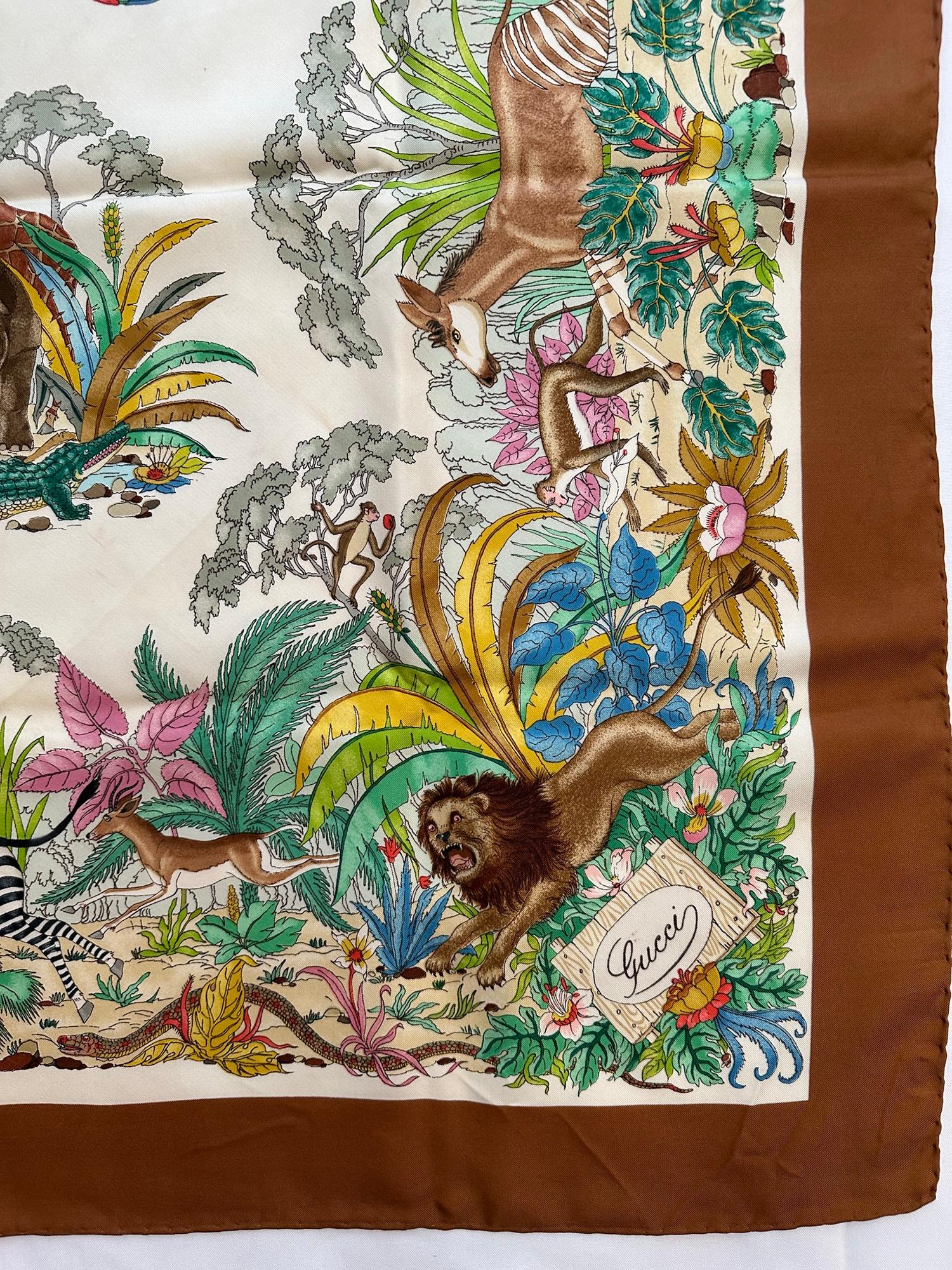 Gucci colourful vintage, The jungle, silk scarf designed by Vittorio Accornero in the 1969. This version is especially gorgeous because of the colourway, the border a dark reddish brown make the assorted flora & fauna + the creatures really pop!