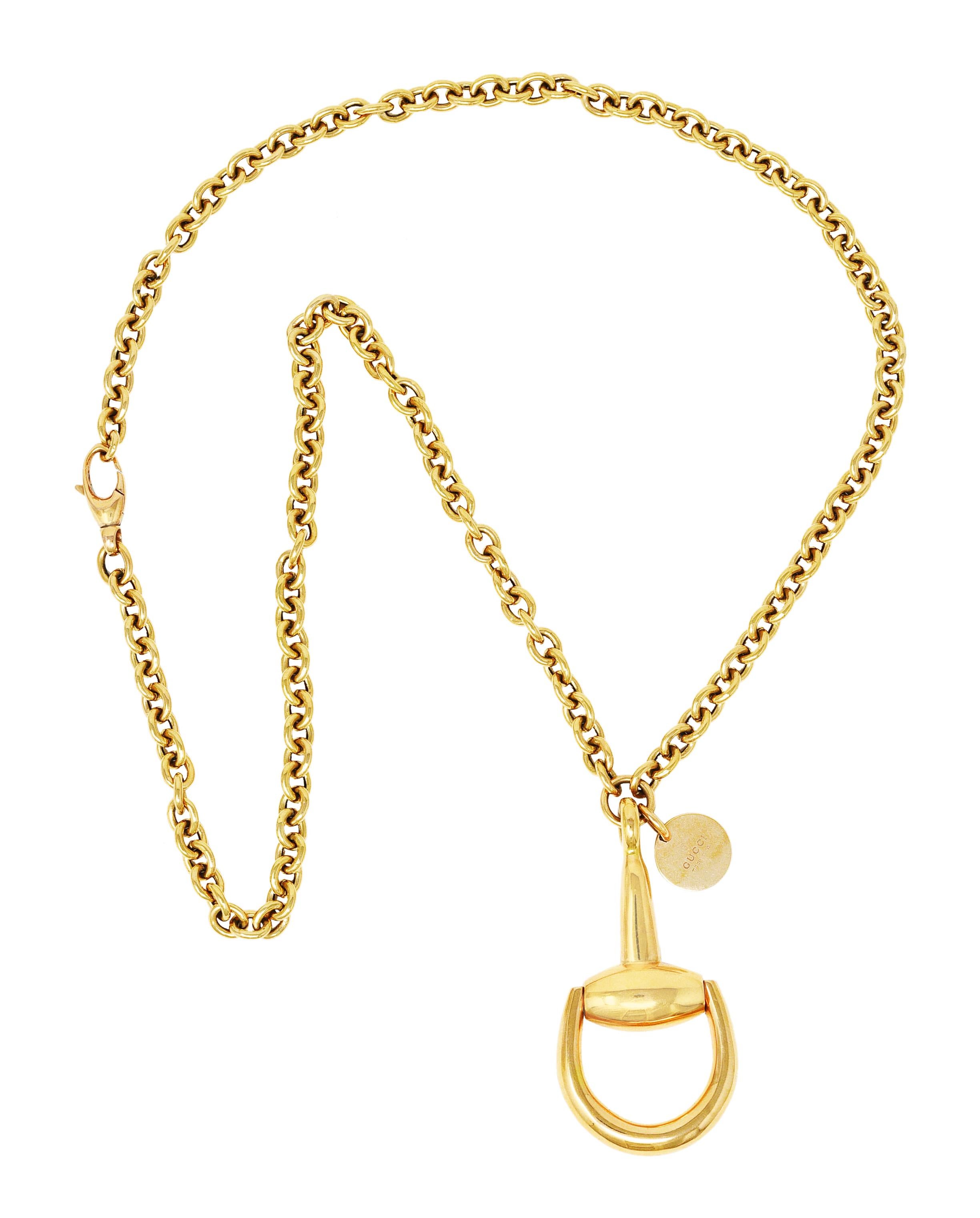 Necklace is designed as cable chain suspending a large horsebit motif pendant. With a hinged loop and a high polished finish. Accented by logo tag. Completed by lobster clasp closure. Stamped AU750 for 18 karat gold. Fully signed Gucci, Made in