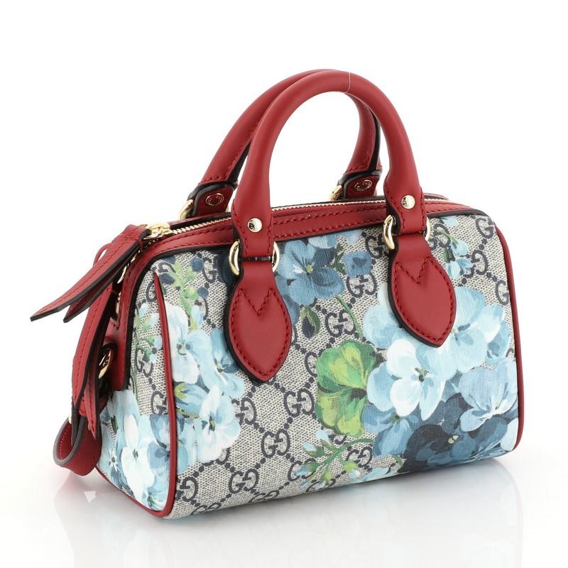 This Gucci Convertible Boston Bag Blooms Print GG Coated Canvas Nano, crafted in blooms print GG coated canvas and red leather, features dual rolled leather handles, leather trim, and gold-tone hardware. Its zip closure opens to a red microfiber