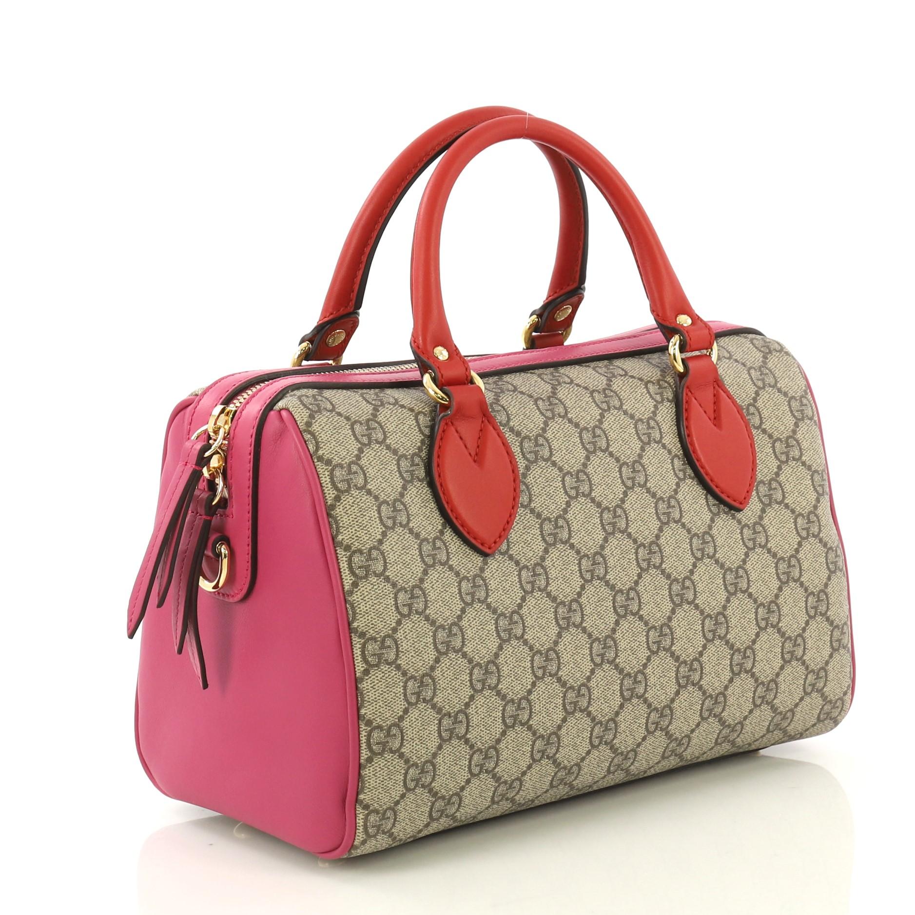 This Gucci Convertible Boston Bag GG Coated Canvas and Leather Small, crafted in brown GG coated canvas and pink leather, features dual rolled leather handles, protective base studs and gold-tone hardware. Its zip closure opens to a brown microfiber