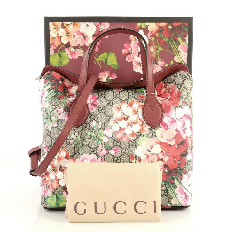 This Gucci Convertible Folded Tote Blooms Print GG Coated Canvas Medium, crafted in brown GG coated canvas with pink blooms print overlay, features dual flat leather handles, and silver-tone hardware. Its fold over top opens to a brown microfiber