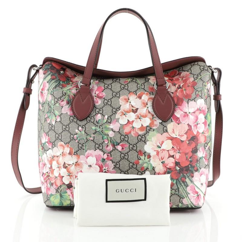 This Gucci Convertible Folded Tote Blooms Print GG Coated Canvas Medium, crafted in brown GG coated canvas with pink blooms print overlay, features dual flat leather handles, and silver-tone hardware. Its fold over top opens to a brown microfiber