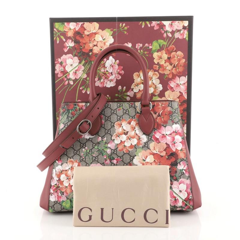 This Gucci Convertible Shopping Tote Blooms Print GG Coated Canvas Large, crafted from blooms print GG coated canvas, features dual rolled leather handles, leather side panels, and aged silver-tone hardware. It opens to a brown microfiber interior