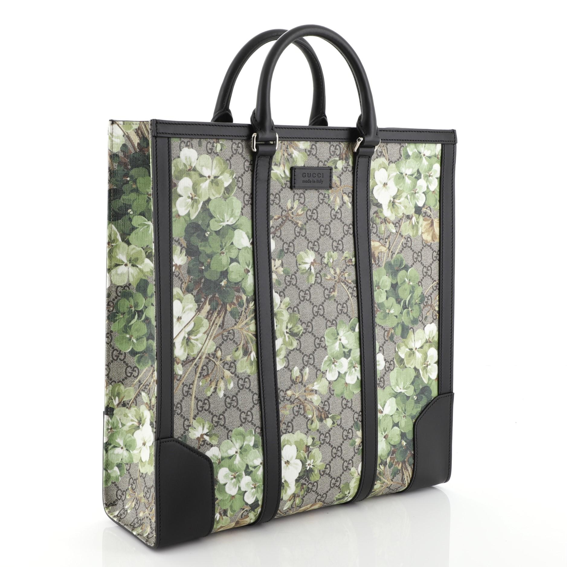 This Gucci Convertible Tote Blooms Print GG Coated Canvas Tall, crafted from brown GG coated canvas with green blooms print overlay, features dual rolled leather handles, leather trim and silver-tone hardware. It opens to a gray microfiber interior.