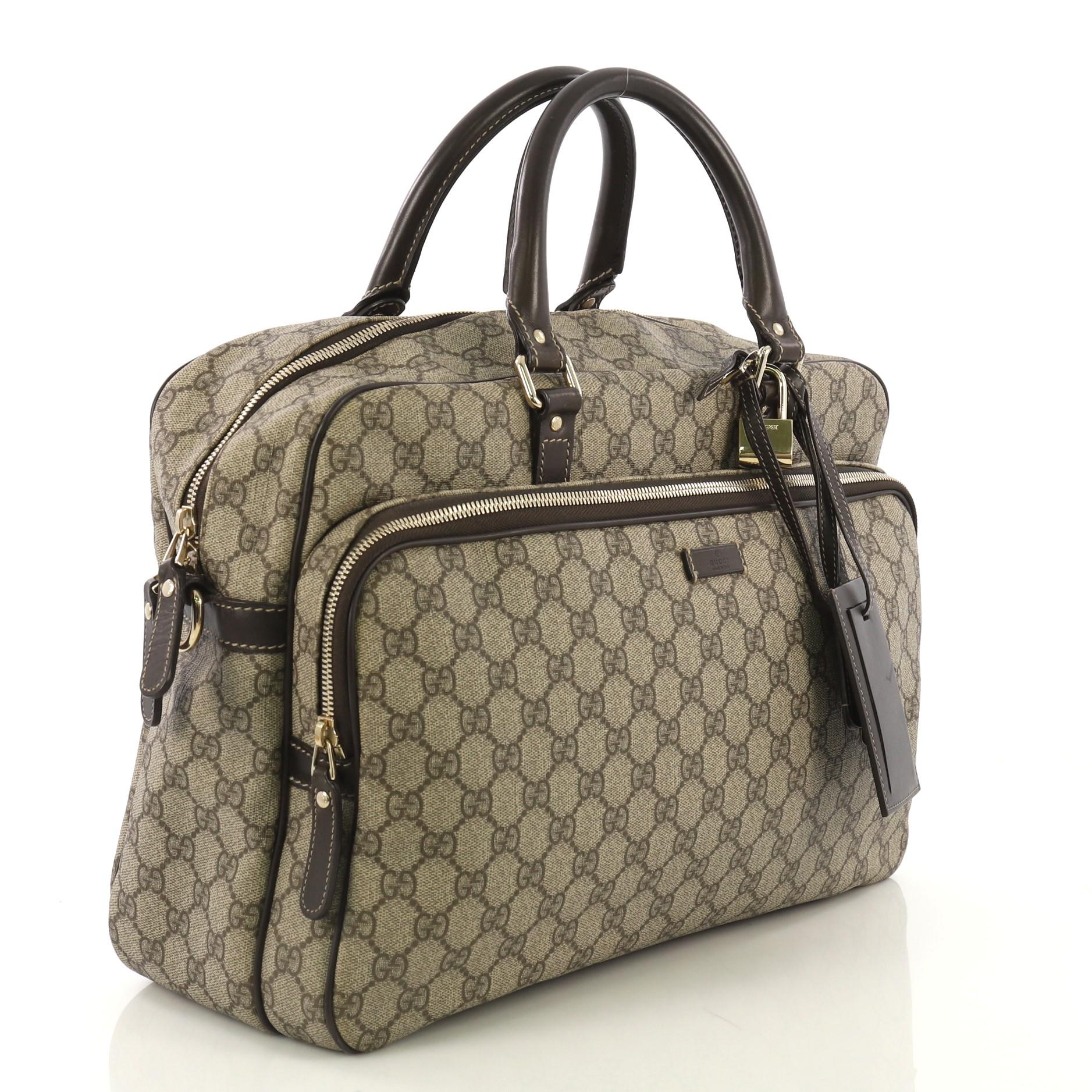 This Gucci Convertible Travel Bag GG Coated Canvas Medium, crafted from brown GG coated canvas and leather, features dual rolled leather handles, leather trim, exterior front zip pocket, and gold-tone hardware. Its zip closure opens to a brown