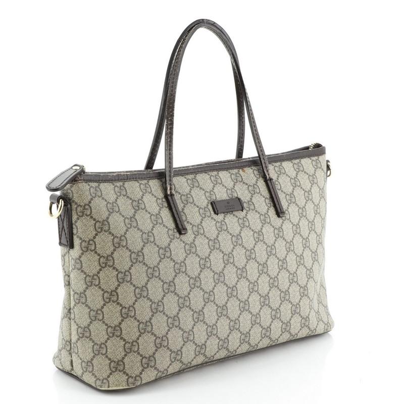 This Gucci Convertible Zip Tote GG Coated Canvas Medium, crafted in brown GG coated canvas with leather trims, features dual slim leather handles, detachable strap, sturdy base and gold-tone hardware. Its zip closure opens to a neutral fabric