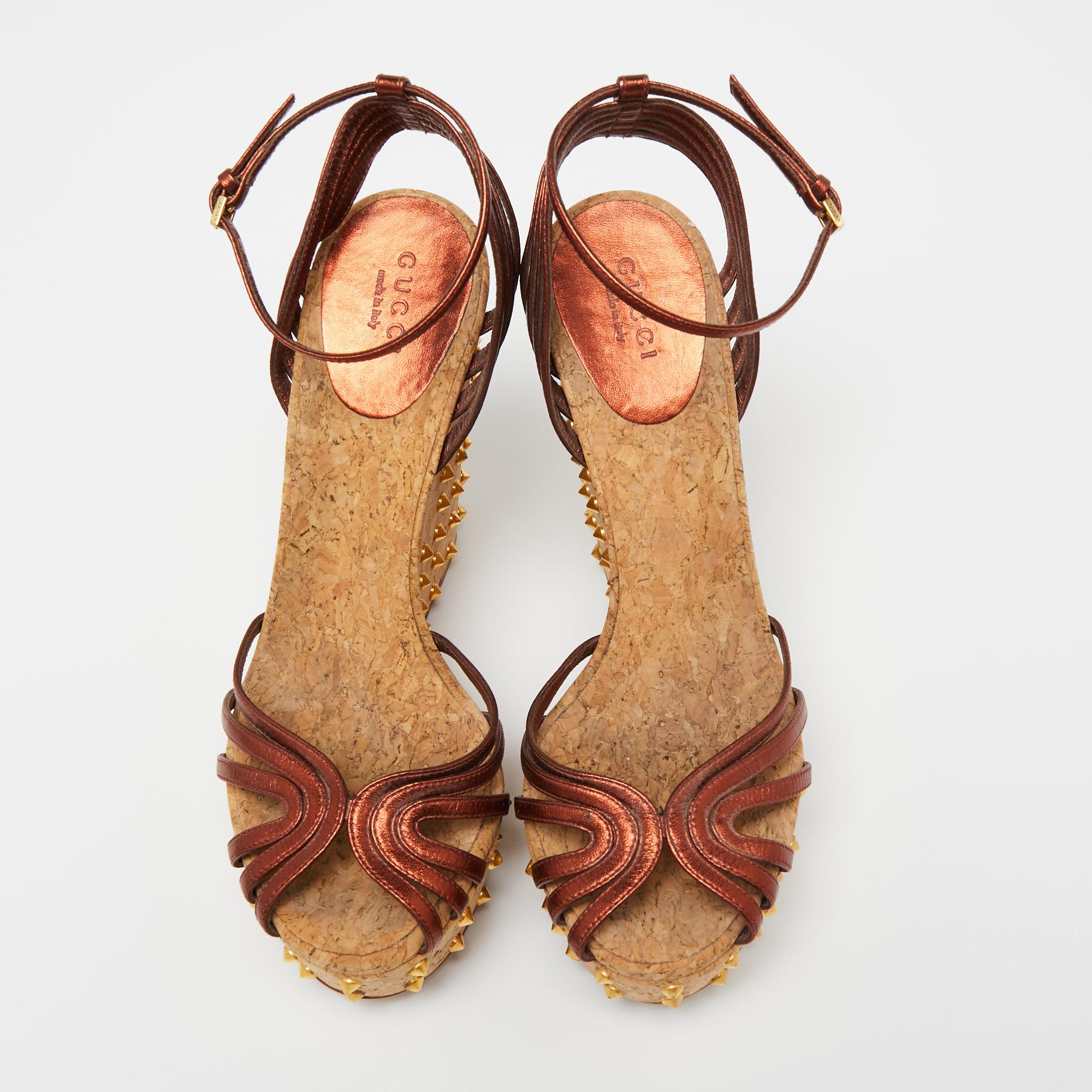These sandals from Gucci have been designed to lift your style. They flaunt copper-hued leather straps to secure your feet perfectly and are elevated on studded cork wedge heels. Pair them with a dress for a fashionable brunch outing and get set to