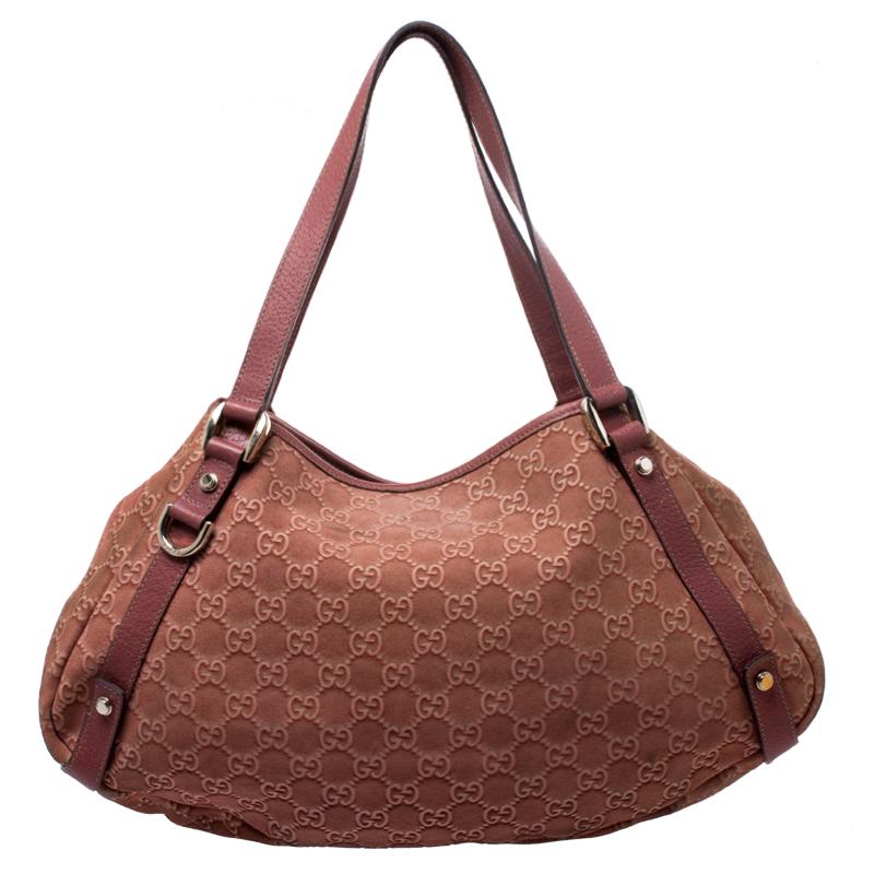 Go for this Gucci hobo bag for a simple and stylish look. Crafted from the brand's signature Guccissima nucbuck and leather, it comes in a lovely shade of coral orange. It is held by dual handles, comes with a fabric interior and gold-tone hardware.