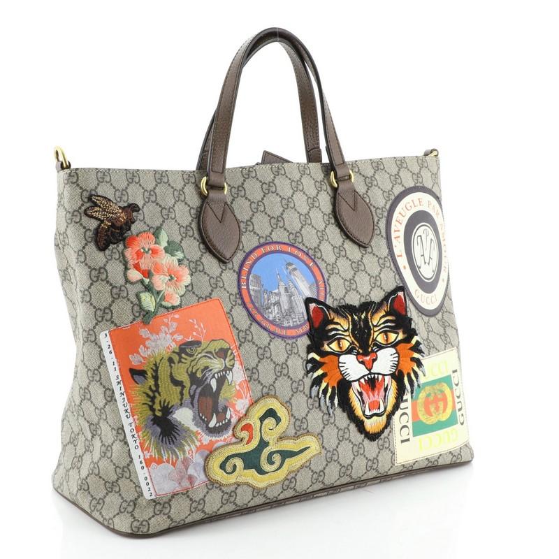 This Gucci Courrier Convertible Soft Open Tote GG Coated Canvas with Applique Large, crafted in brown GG coated canvas, features dual flat leather handles, embroidered appliques, and gold-tone hardware. Its magnetic closure opens to a neutral fabric