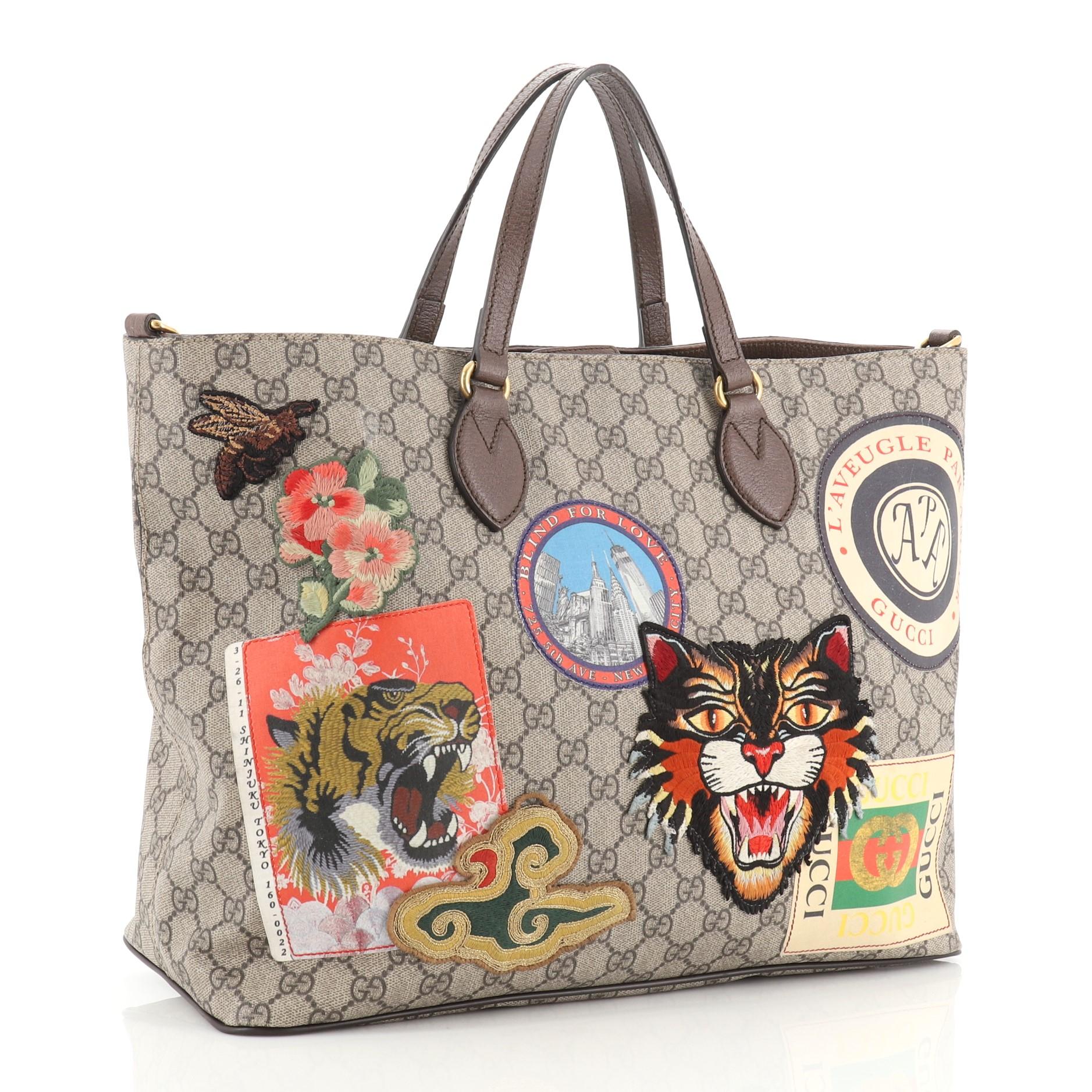 This Gucci Courrier Convertible Soft Open Tote GG Coated Canvas with Applique Large, crafted in brown GG coated canvas, features dual flat leather handles, embroidered appliques, and aged gold-tone hardware. Its magnetic closure opens to a neutral