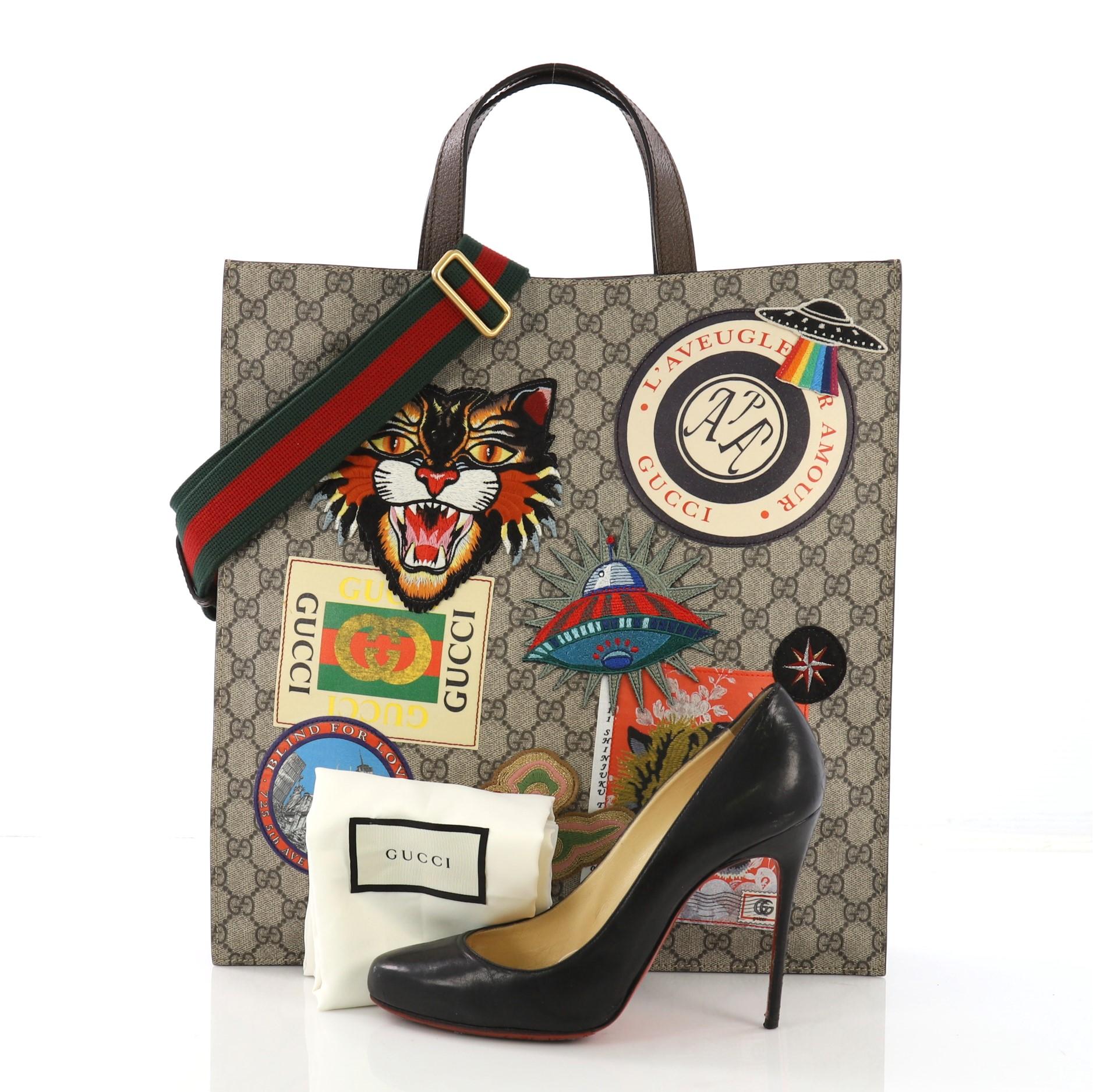 This Gucci Courrier Convertible Soft Open Tote GG Coated Canvas with Applique North South, crafted in GG coated canvas, features courrier applique design, dual flat leather handles, and aged gold-tone hardware. Its magnetic snap closure opens to a