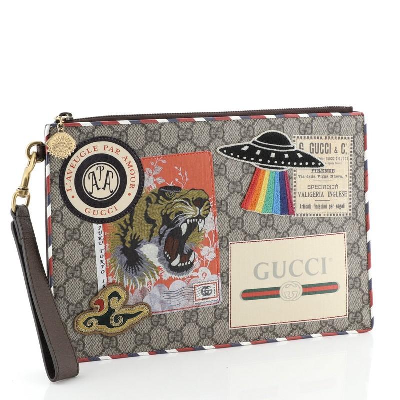 This Gucci Courrier Pouch GG Coated Canvas with Applique, crafted in neutral coated canvas, features a hand strap, multicolor applique design, and aged gold-tone hardware. Its zip closure opens to a neutral canvas interior with multiple card slots.