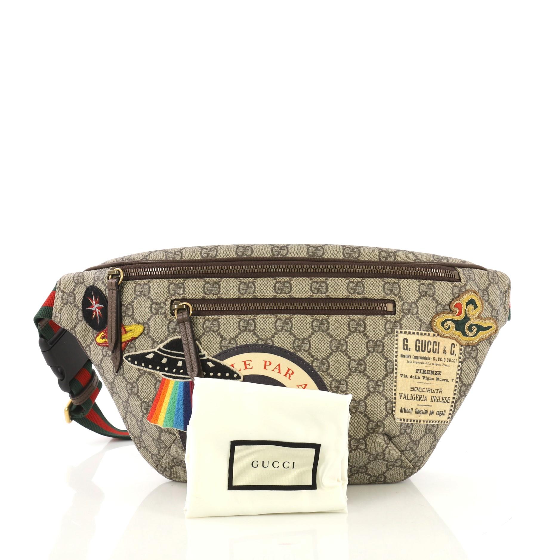 This Gucci Courrier Zip Belt Bag GG Coated Canvas with Applique, crafted from brown GG coated canvas with applique, features a web belt strap, exterior zip pocket, and aged gold-tone hardware. Its zip closure opens to a beige fabric interior.