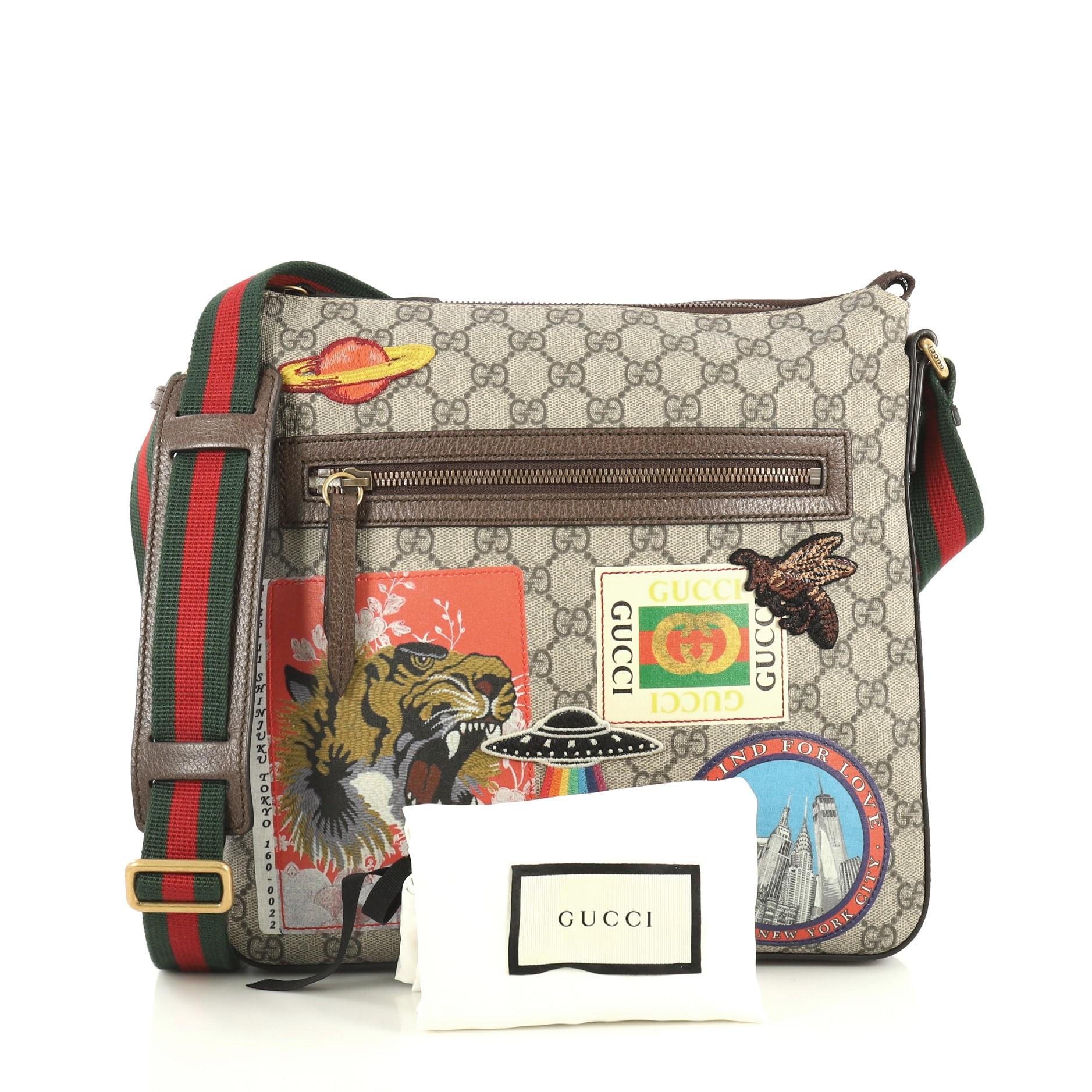 This Gucci Courrier Zip Messenger GG Coated Canvas with Applique Medium, crafted in brown GG supreme coated canvas, features an adjustable web strap, exterior front zip pocket, leather trim, embroidered multicolor appliques, and bronze-tone
