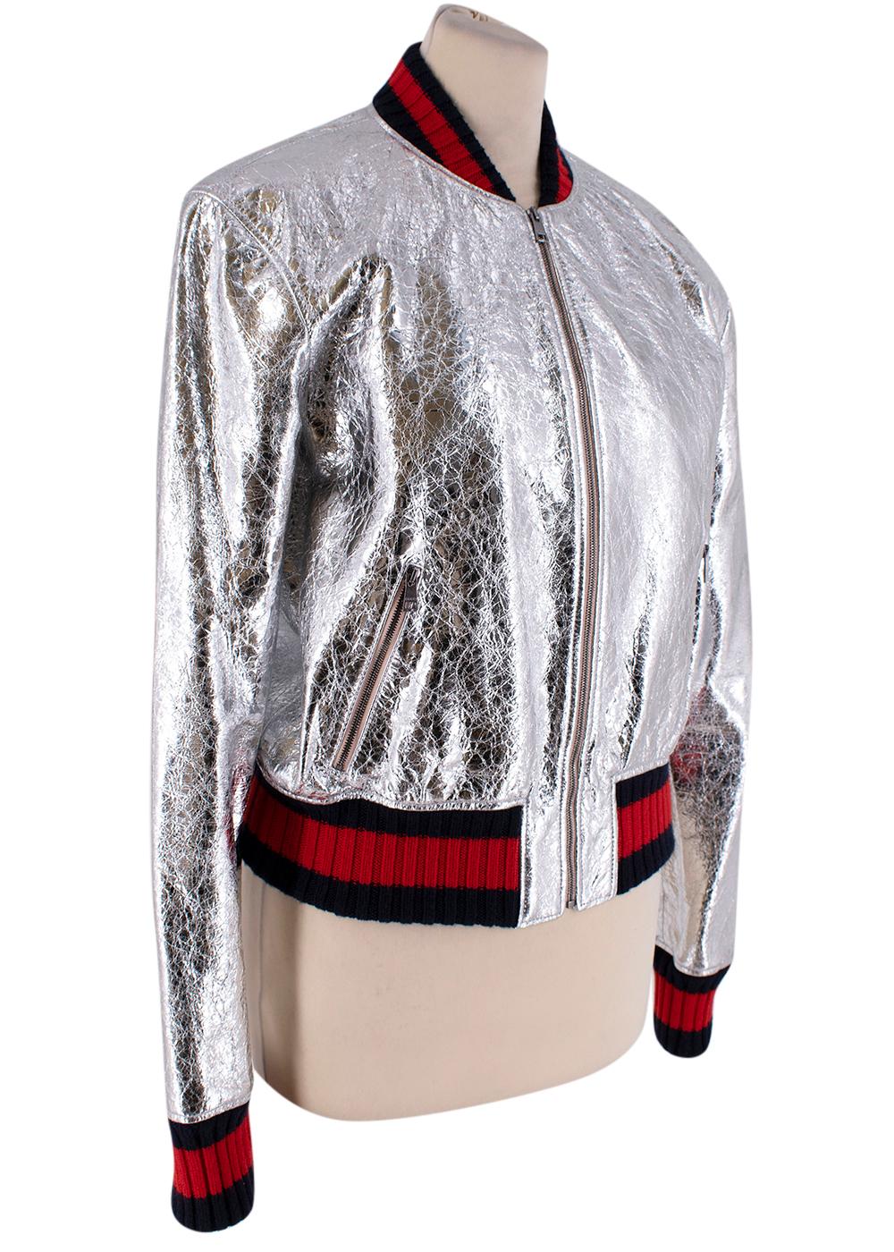 This jacket is single breasted, with zipper front. Two front pockets, with zippers. Interior is fully lined and is filled with silk lining  The exterior is finished with the label's iconic navy and red 'web stripe' trims and lined in floral-print