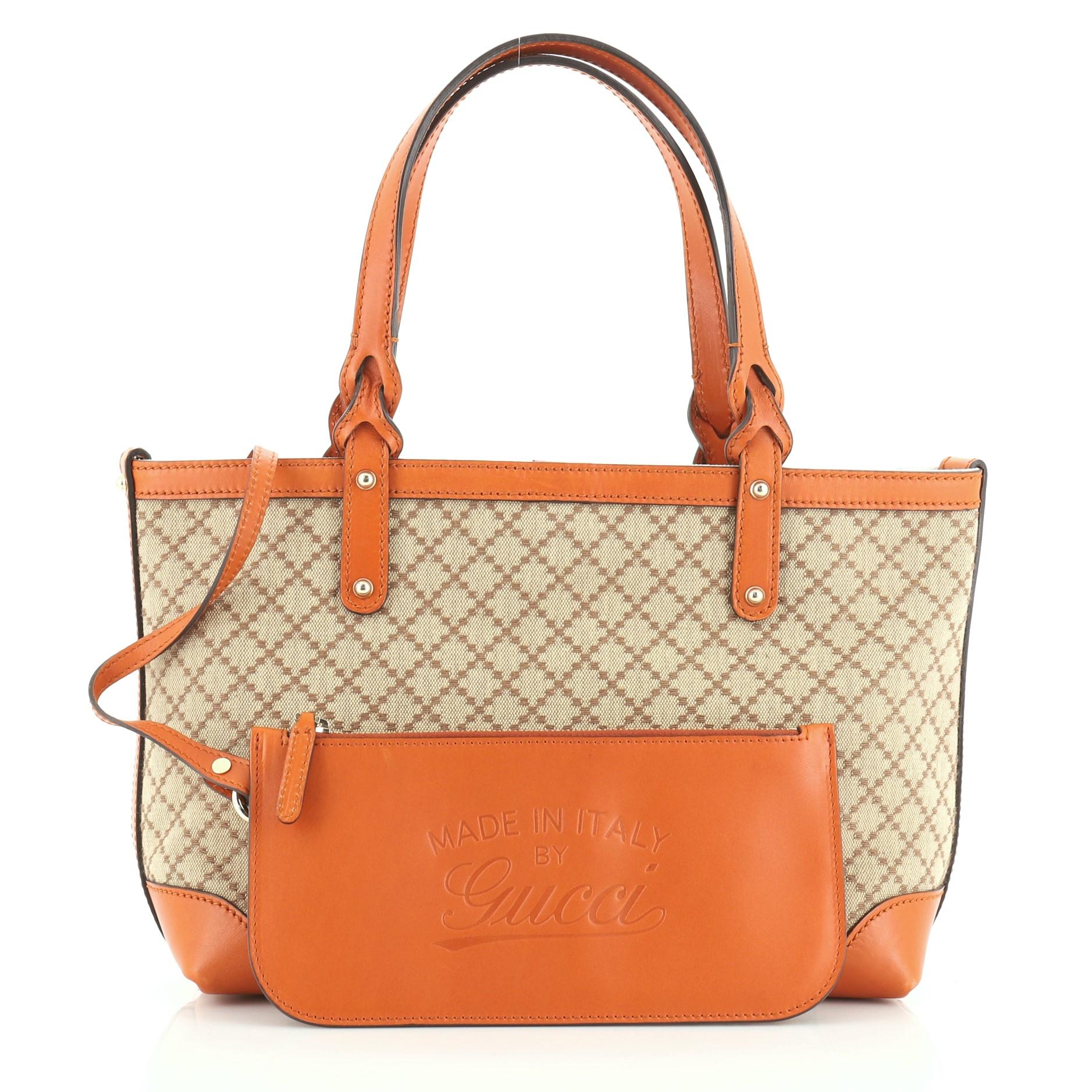 This Gucci Craft Tote Diamante Canvas Small, crafted from brown diamante canvas with orange leather trims, this tote features dual-flat handles with braided ends and gold-tone hardware. Its hook closure opens to a neutral fabric interior.