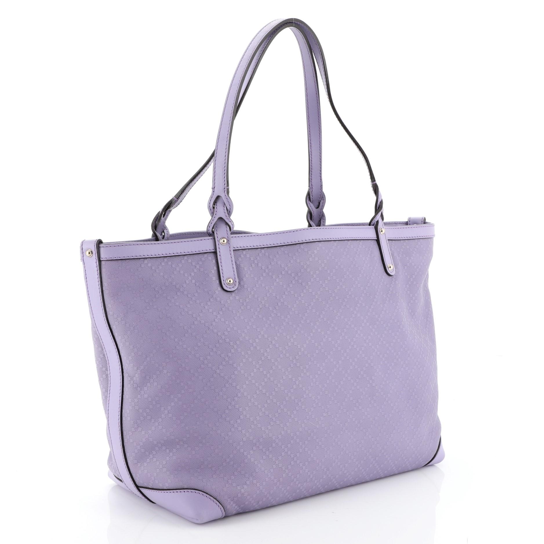 This Gucci Craft Tote Diamante Leather Medium, crafted from purple diamante pattern leather, features dual-flat handles with braided ends, and gold-tone hardware. Its snap hook closure opens to a neutral fabric interior with zip and slip pockets.