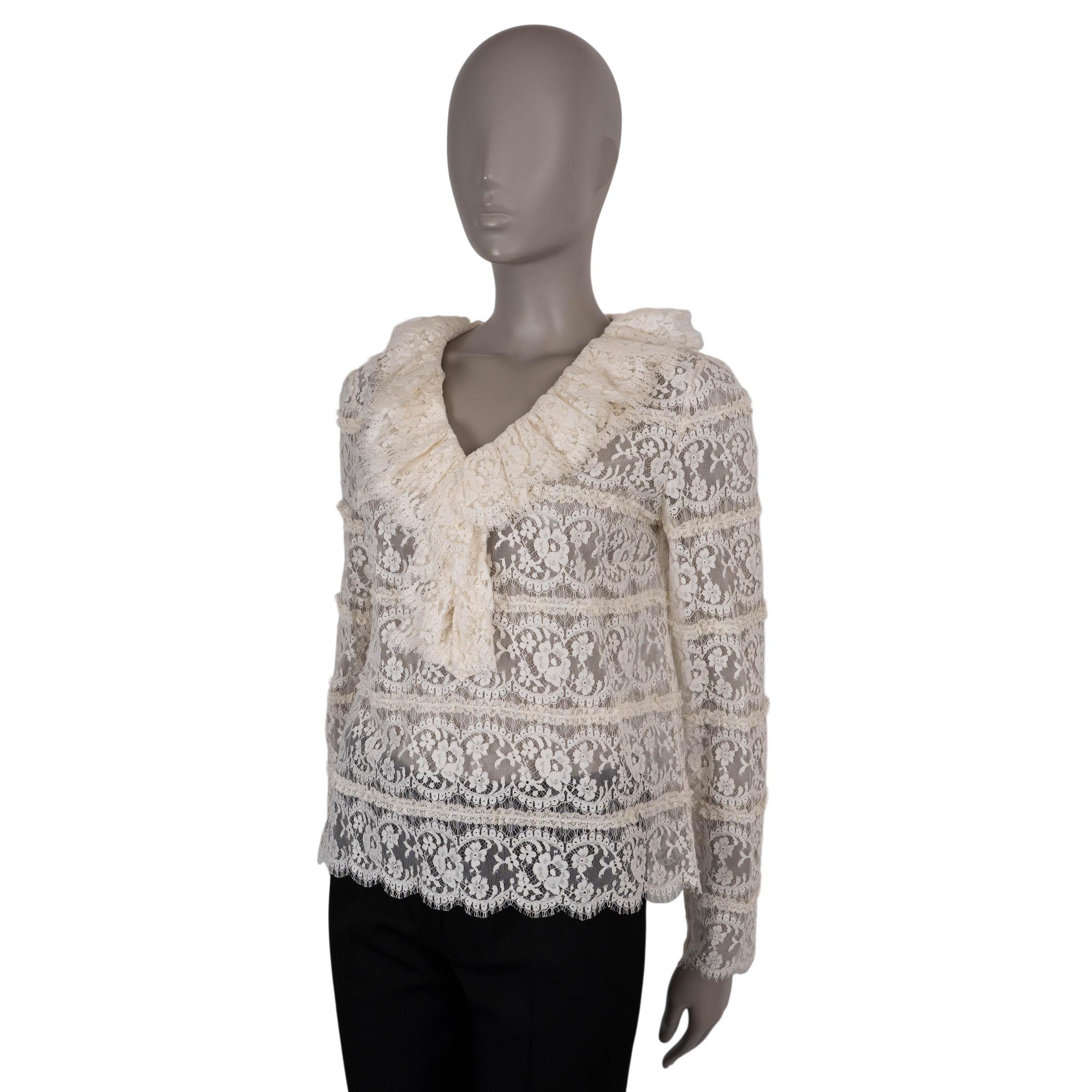 Questa camicetta 100% autentica di Gucci è realizzata in pizzo floreale color crema in cotone (65%) e poliammide (35%). Presenta un design semitrasparente con un femminile scollo a V, rifinito con volant e rifinito con un delicato fiocco. La
