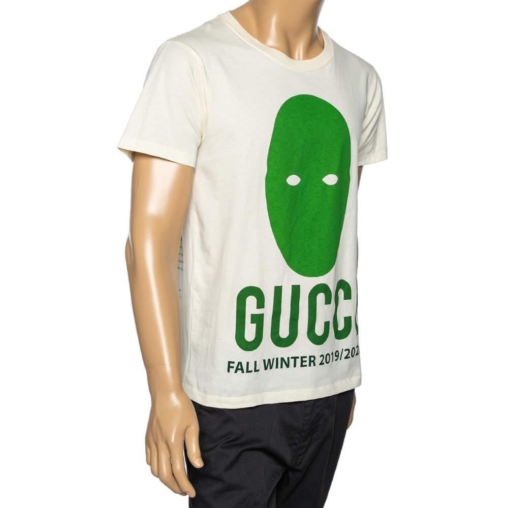 Gucci präsentiert Ihnen ein schlichtes T-Shirt, das durch einen leuchtenden Manifesto Mask-Print auf der Vorderseite aufgewertet wird. Es ist aus cremefarbener Baumwolle gefertigt und hat kurze Ärmel. Stylen Sie die Kreation mit Sneakers und