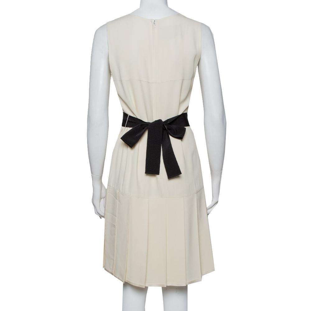 A Gucci dress to exhibit your fantastic styling choices to the world! The cream crepe creation has been designed with a zip closure, a belt detailing on the waist, and a round neckline. It comes equipped with a pleated hem and is sure to lend you a