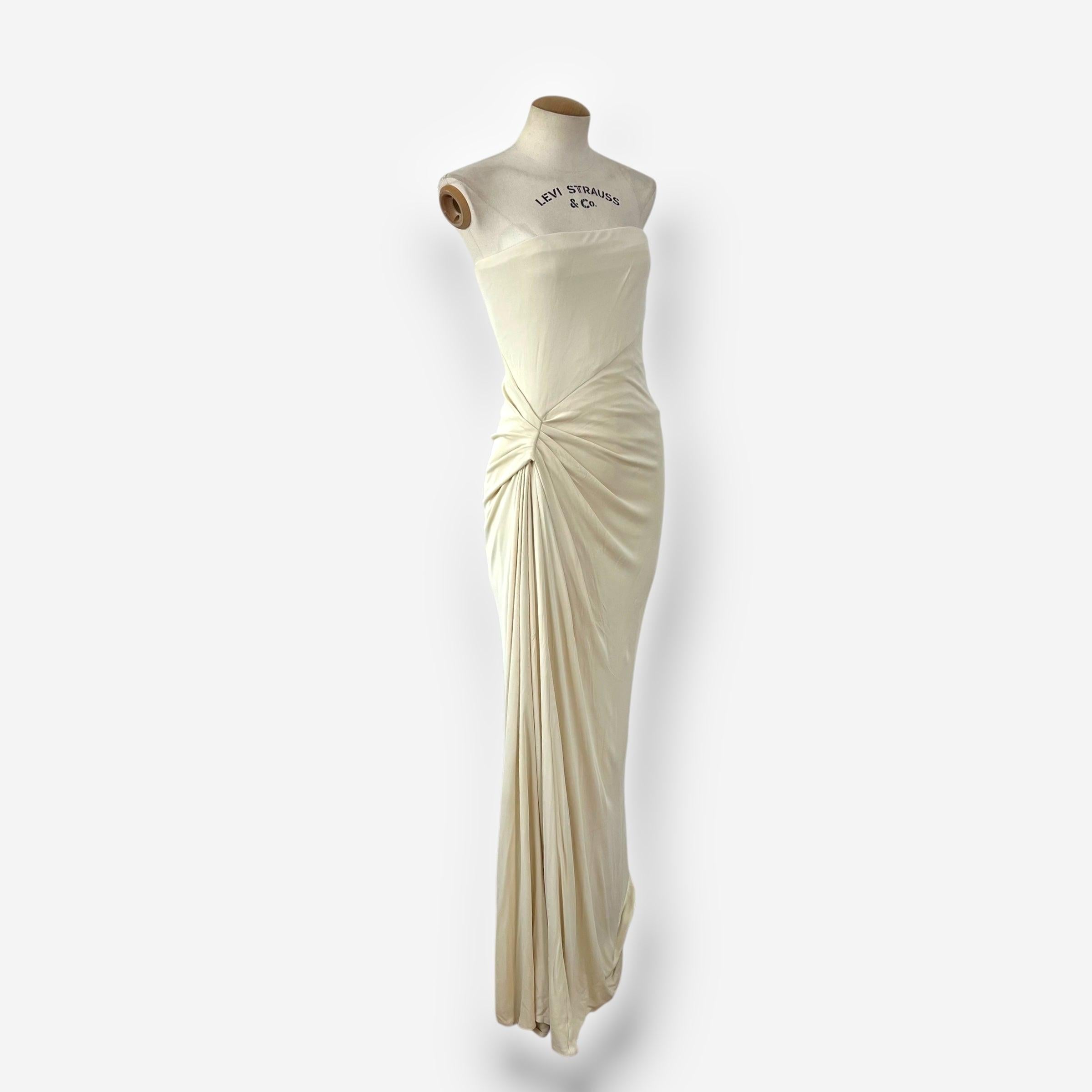 This refined cream gown from Gucci’s 2010 collection showcases the brand’s elegant, sculptural aesthetic under Frida Giannini. Crafted with internal corsetry, the strapless bodice is cleanly structured, while the side-gathered draping adds soft