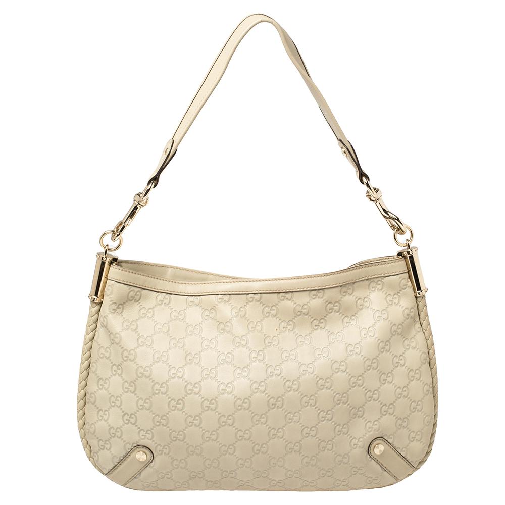A striking companion for your outings, this wondrous Britt hobo by Gucci is one of its kind. It has been crafted in cream Guccissima leather. The exterior features a braided trim extending to form a shoulder strap and gold-tone embellishment. GG