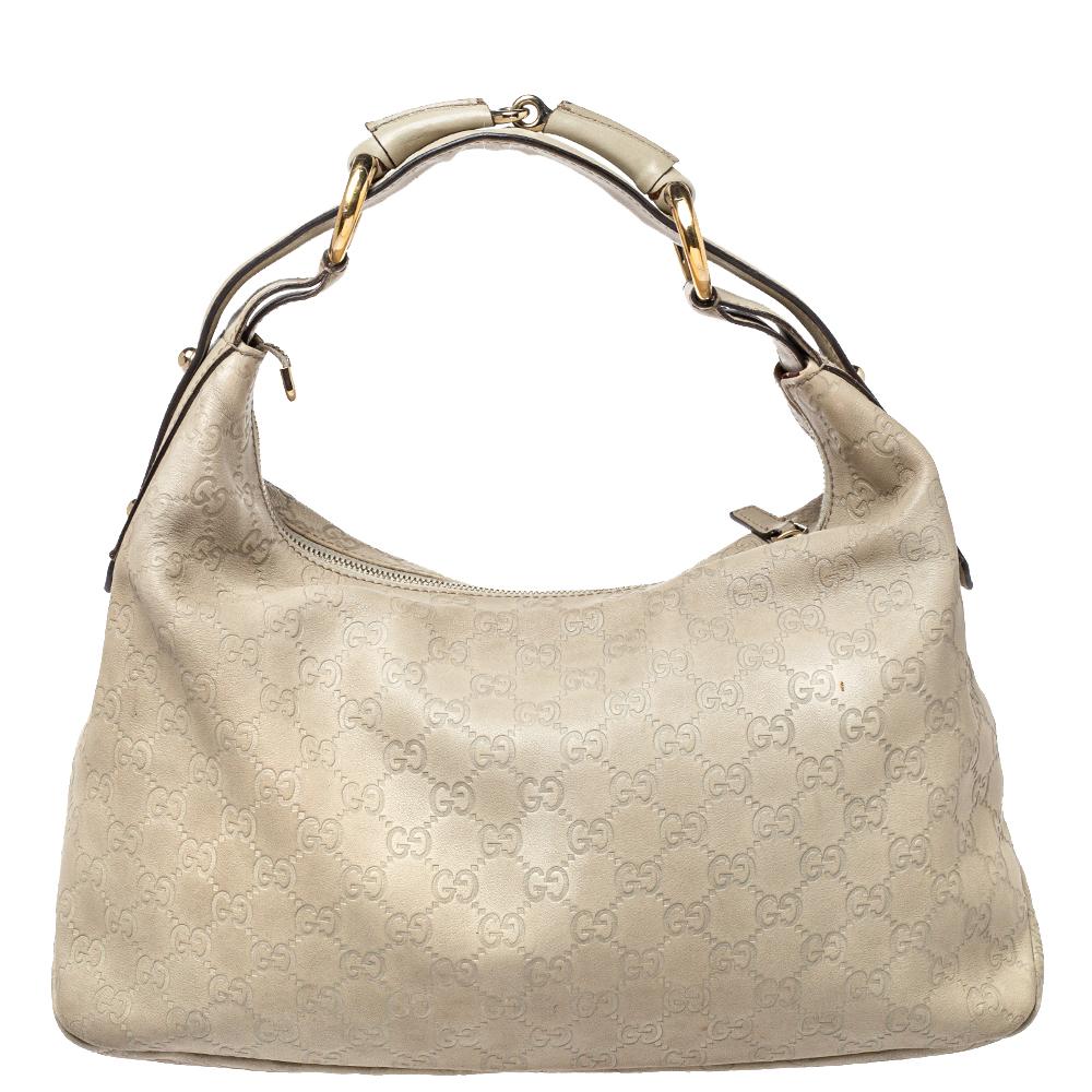 Beautifully designed, this Gucci hobo is crafted from Guccissima leather and detailed with the signature Horsebit accent on the leather handle. Spacious and super handy, the cream-hued bag comes with a canvas-lined interior for your essentials.

